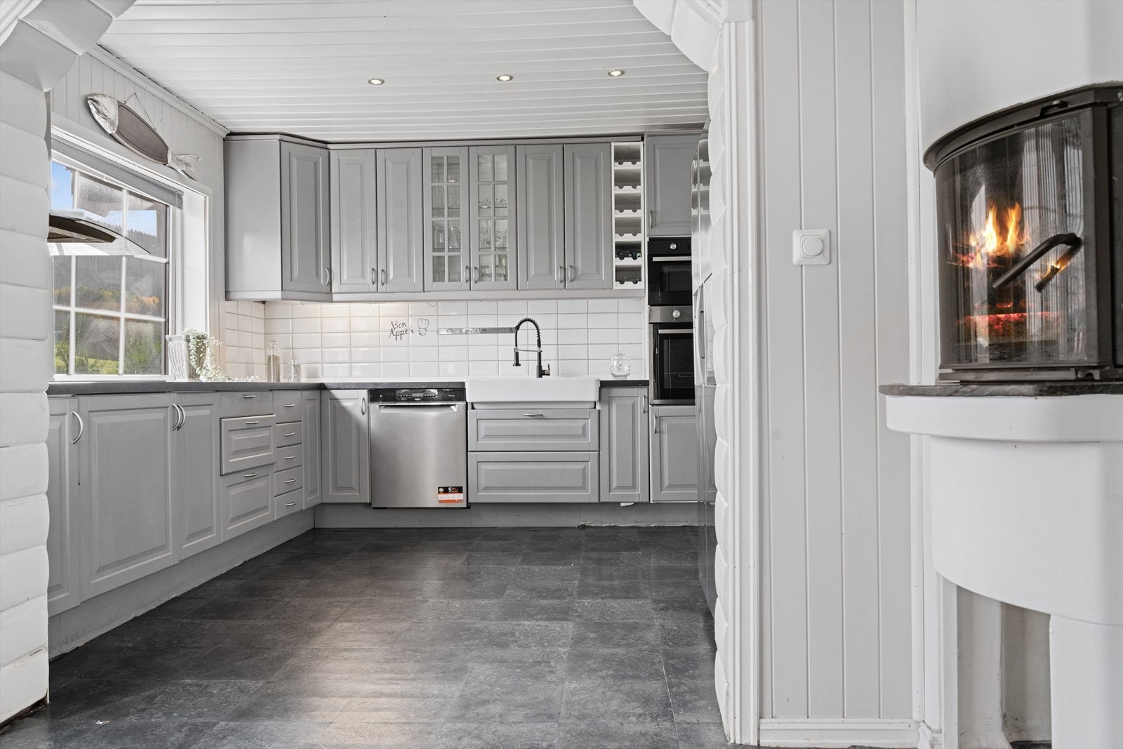 Innredningen har malte fronter i profilert utførelse, og laminert benkeplate med oppvaskkum av porselen med ett-greps blandebatteri. Galleribilde