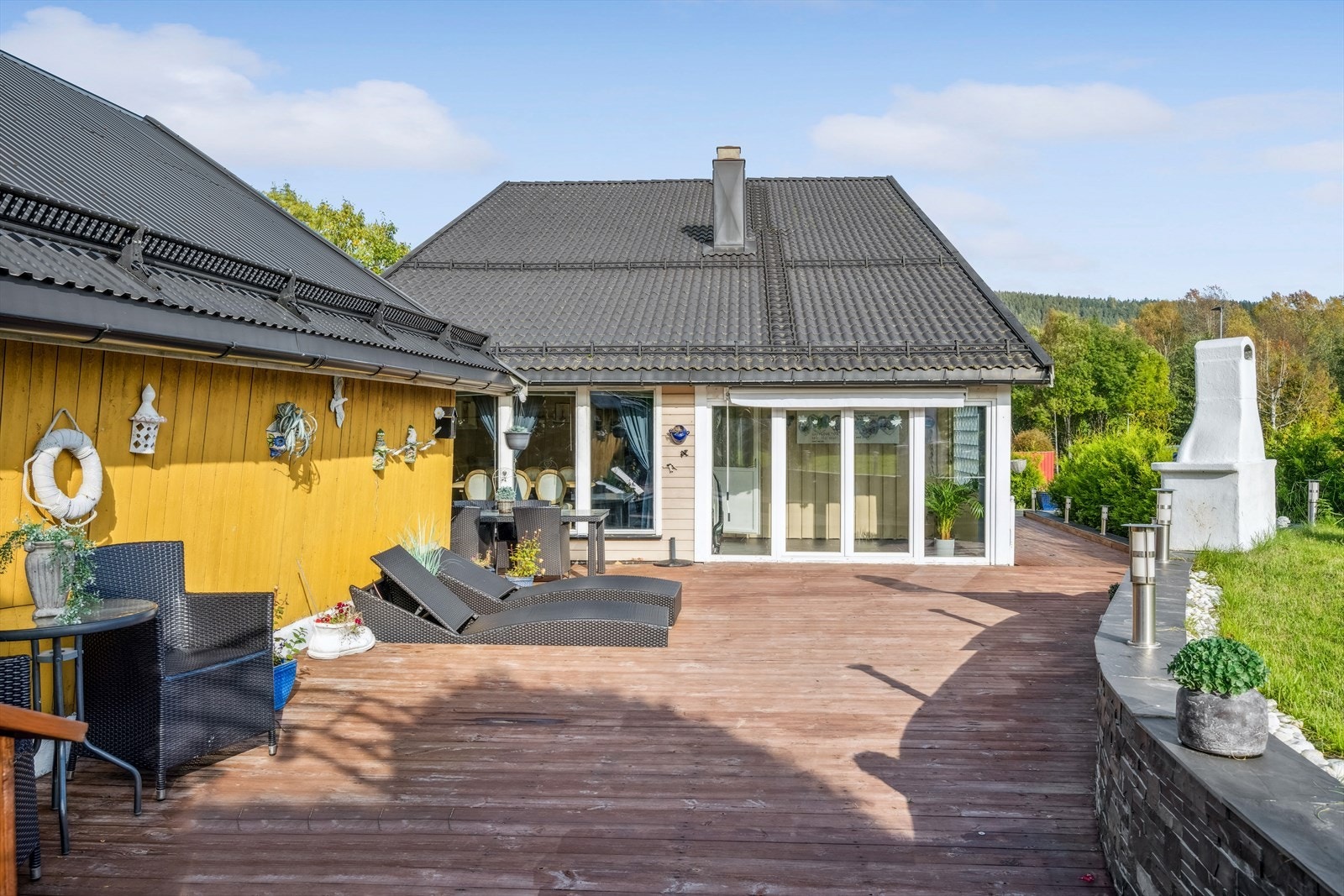 Uteområdet på tomten er usjenert og pent opparbeidet med støtte-mur og stor terrasse. Galleribilde