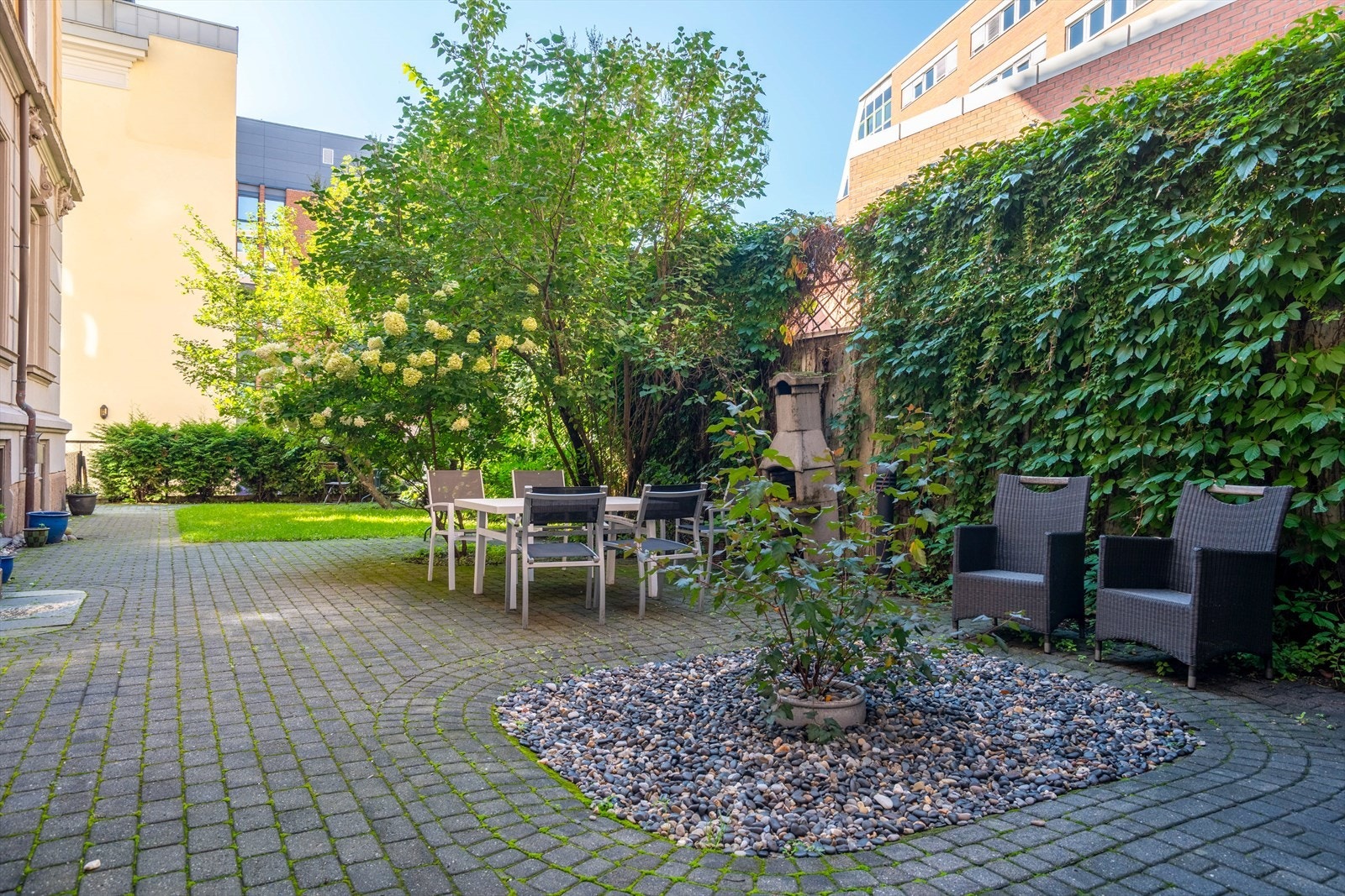 Hyggelig bakgård med sittegrupper og beplantning Galleribilde