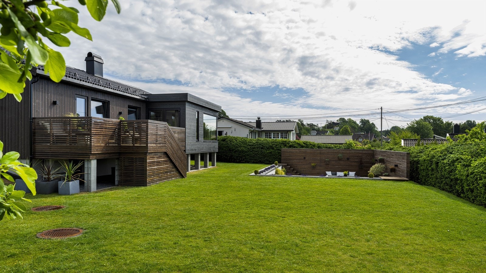 Boligen har parkmessig opparbeidet hage med nedsenket uteareal Galleribilde