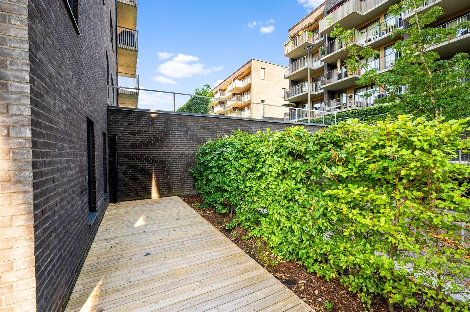 Terrassen er lagt med terrassebord, i tillegg til at det er beplantning som skjermer godt. Naturligvis fungerer terrassen som en forlengelse av stuen på sommerhalvåret. Galleribilde
