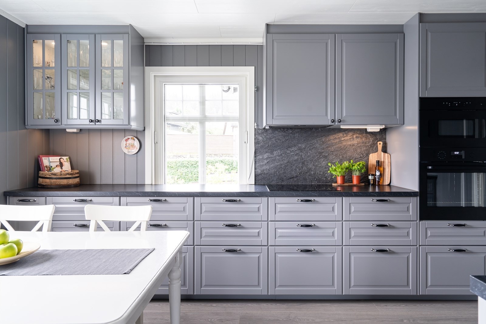 Kjøkkenet holder høy standard med grå profilerte fronter, og mørk benkeplate. Galleribilde