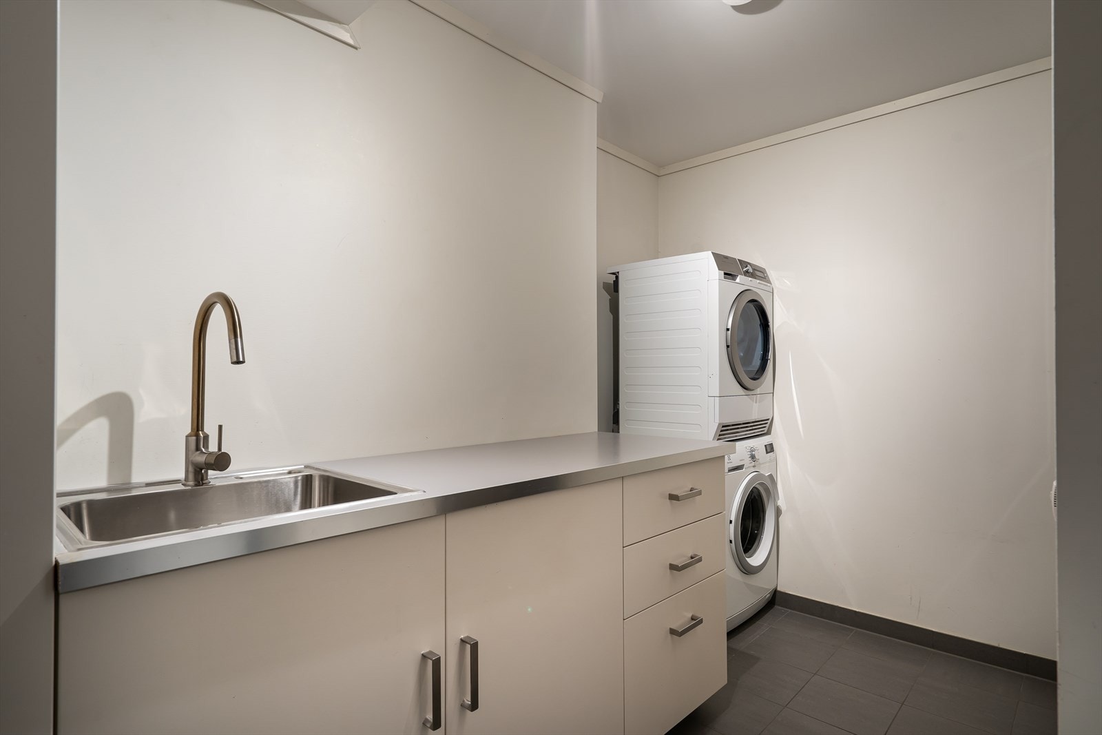 Vaskerommet er av god størrelse med opplegg for vaskesøyle. Det er også praktisk innredning og utlagsvask. Galleribilde