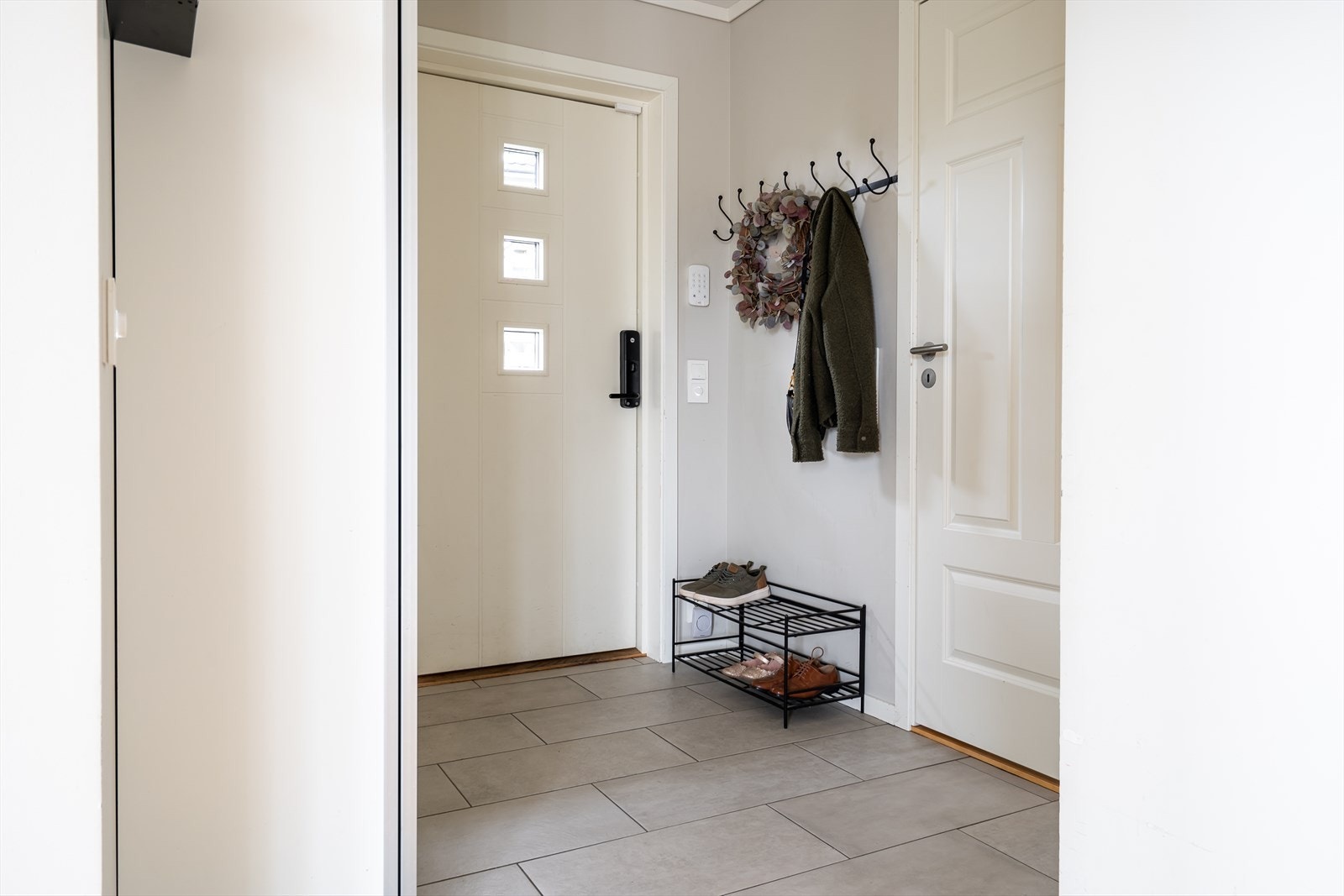 Når du kommer inn i boligen blir du møtt av en innbydende entré med fliser på gulv og lyse farger på veggene. Entreen er også utstyrt med garderobeskap. Galleribilde