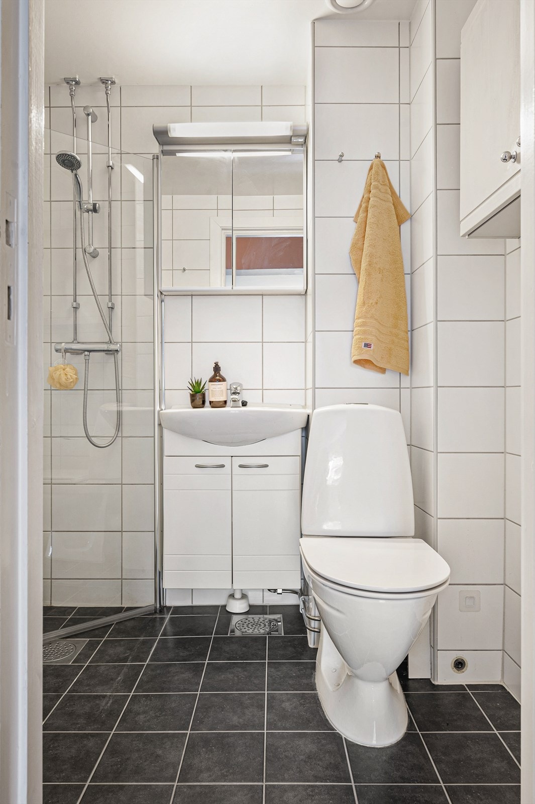 Badet flislagt og har varmekabler i gulv. Det ble satt inn nye dusjdører i 2024. Galleribilde