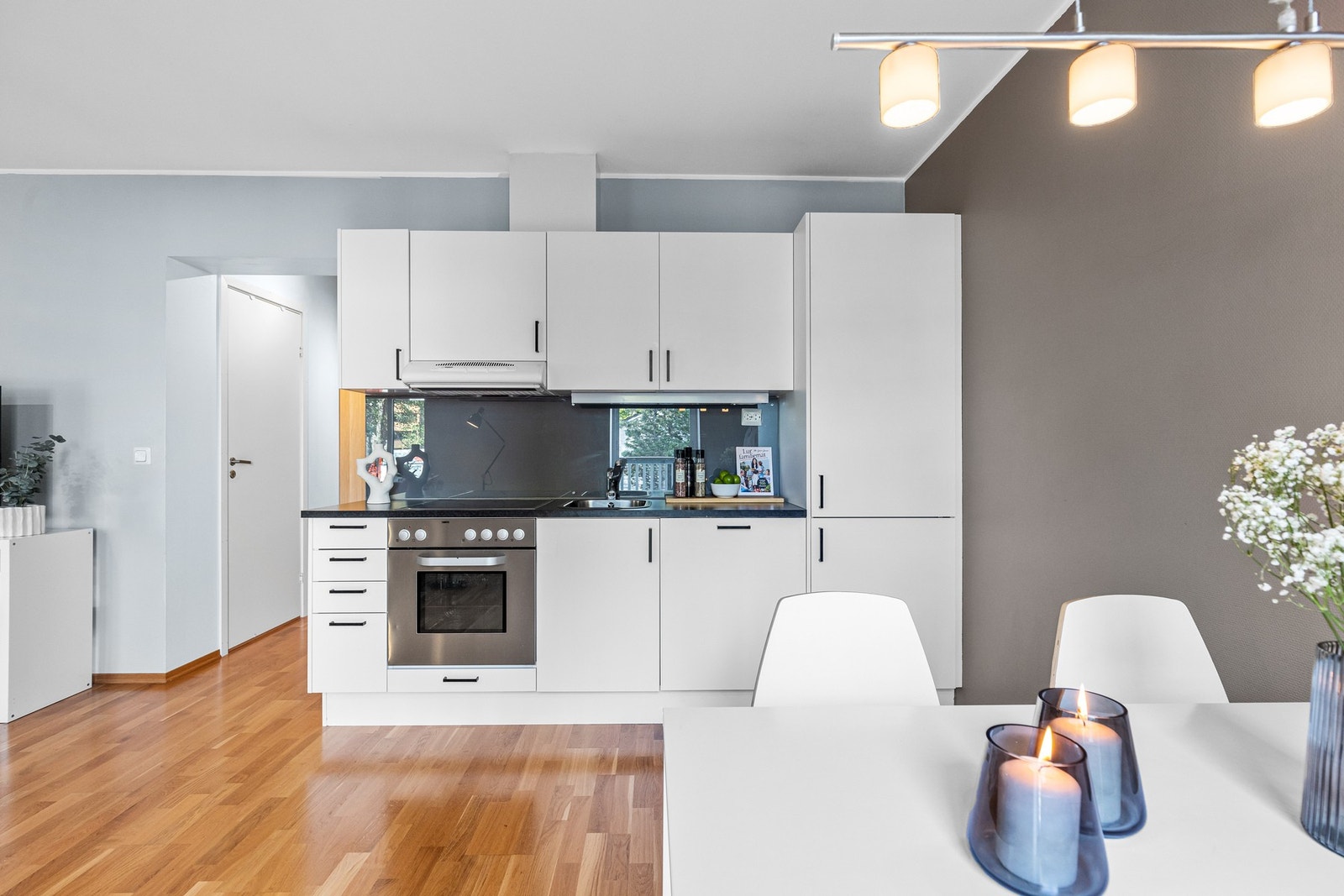 Praktisk kjøkken med integrerte hvitevarer som stekeovn, platetopp, ventilator, frys- og kjøleskap. Galleribilde