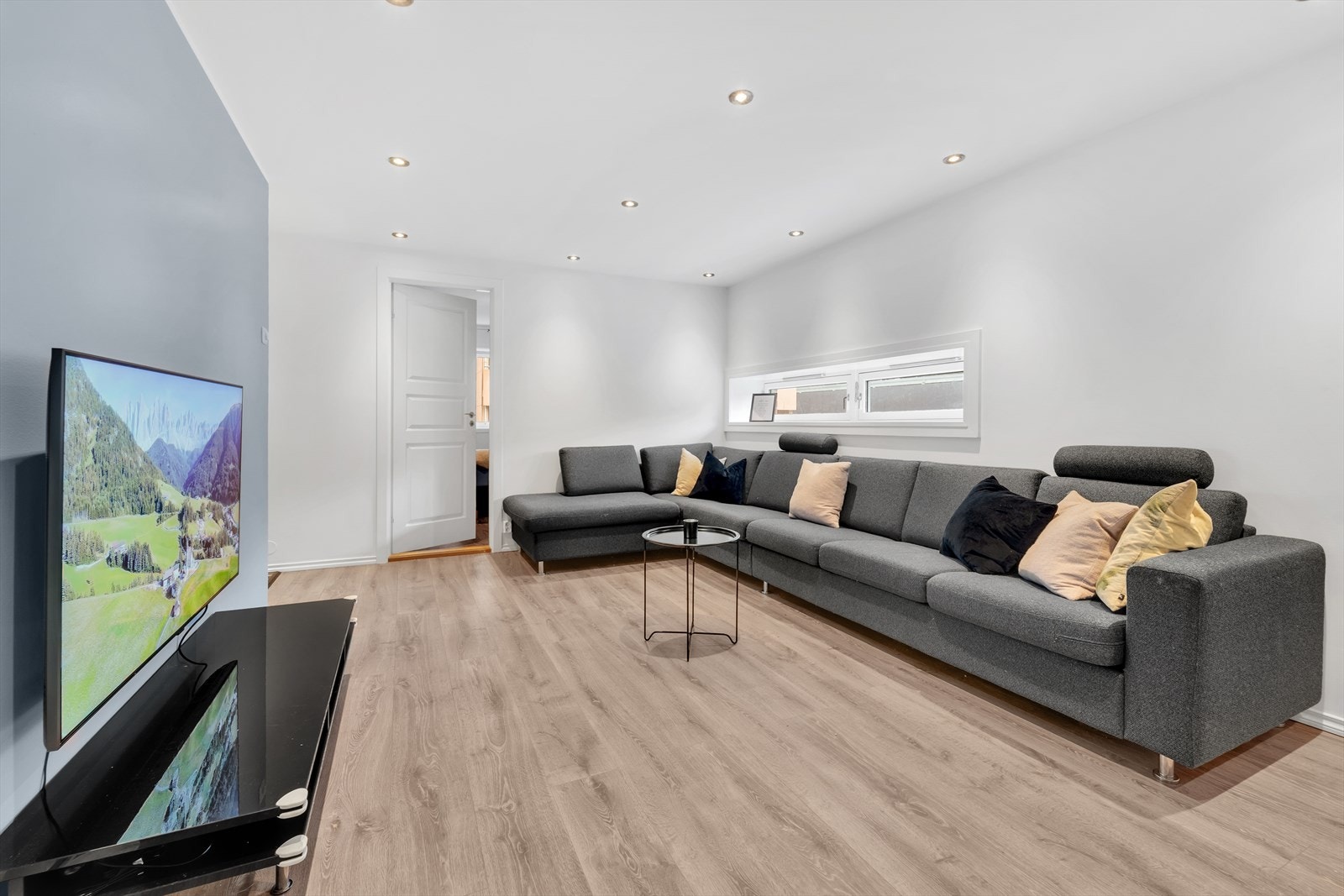 Det er laminat på gulvet, malte overflater og downlights i taket. Da det er en endeleilighet får man ekstra lysinnslipp fra vinduene i endeveggen. Galleribilde