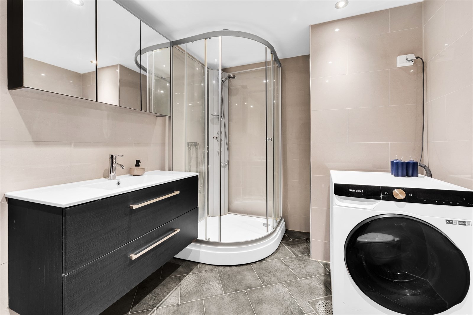 Innredningen består av dusjkabinett, servant med underskuffer, overskap med speilfronter, veggskap, vegghengt wc, opplegg for vaskemaskin og varmekabler i gulv. Galleribilde