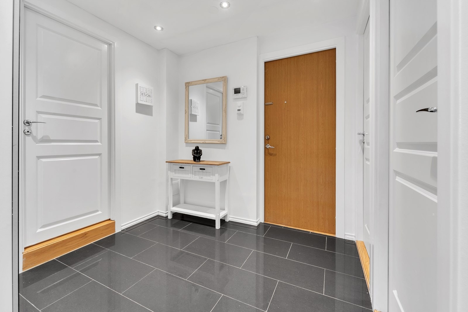 Entré med plass for å henge fra seg yttertøy og sette fra seg sko. Downlights i tak og fliser på gulv med elektrisk oppvarming. Galleribilde