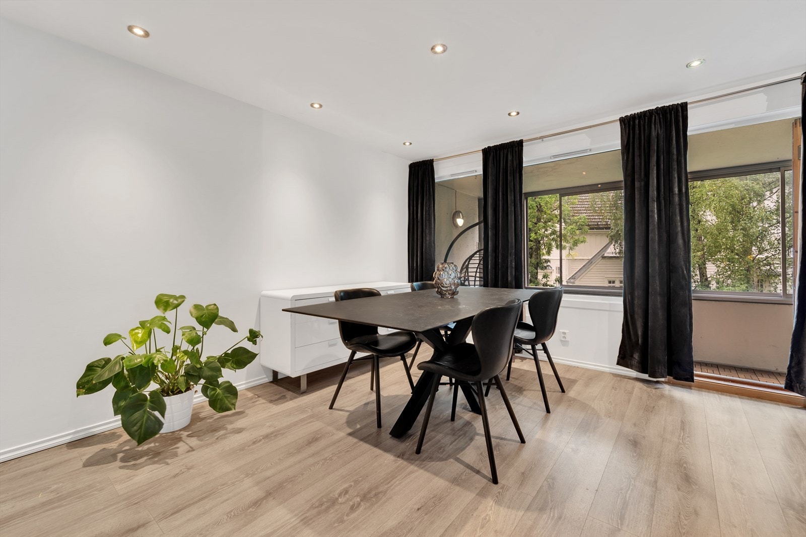 Romslig, lys og luftig stue med laminat på gulv, malte slette vegger og malt tak med downlights. Galleribilde