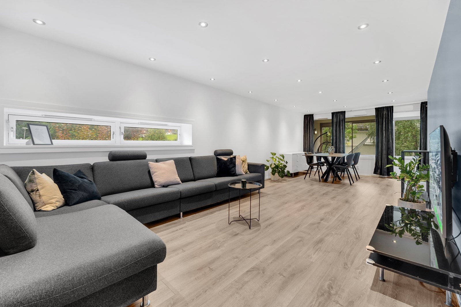 Stor stue med plass for sofa, sofabord, TV-møbler, spisegruppe og andre stuemøbler. Galleribilde