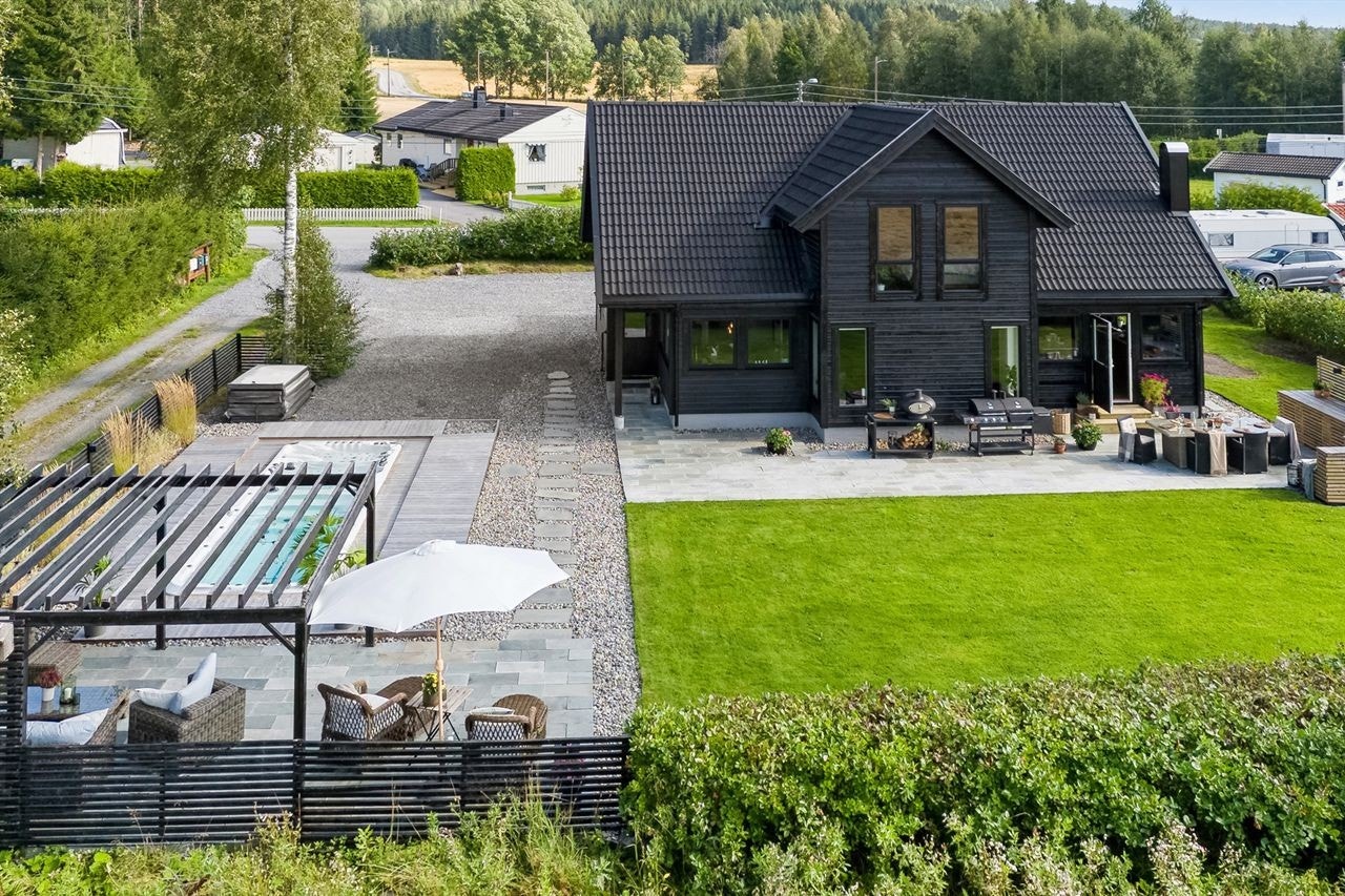 Moderne enebolig med stor hage, uteplass og pergola. Flott beliggenhet i rolige omgivelser nær natur, ideelt for barnefamilier. Galleribilde