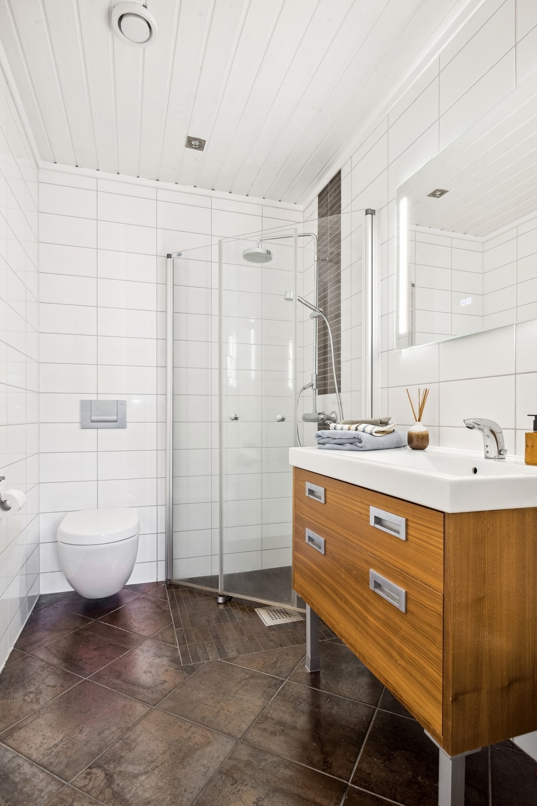 På badet er det dusj med innfellbare glassvegger, vegghengt toalett og innredning med nedfelt servant. Galleribilde