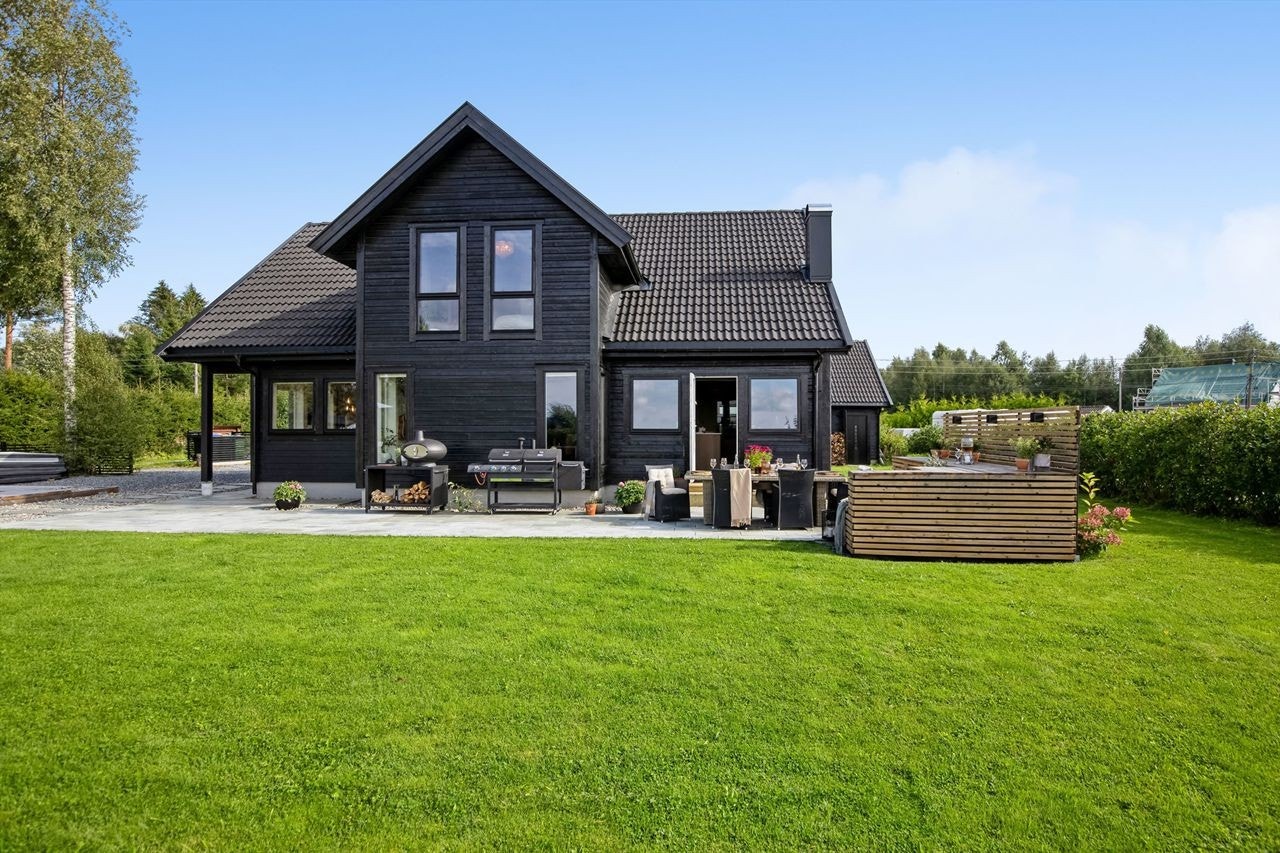 Moderne enebolig med stor hage, solrik terrasse og rolig beliggenhet i naturskjønne omgivelser. Perfekt for barnefamilier. Galleribilde