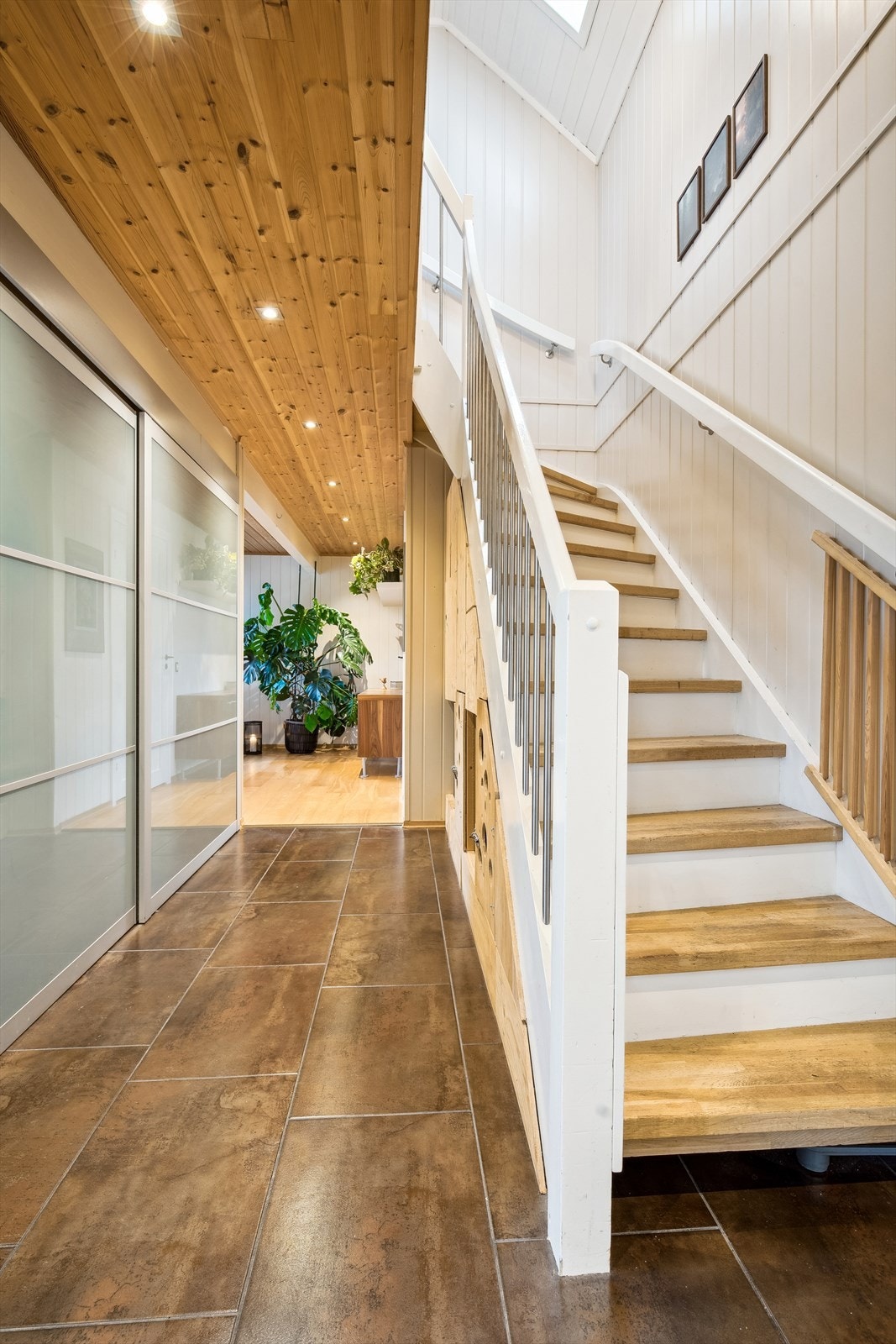 Trappegang med fliser på gulvet. Spotter i taket. Stor skyvedørsgarderobe. Galleribilde