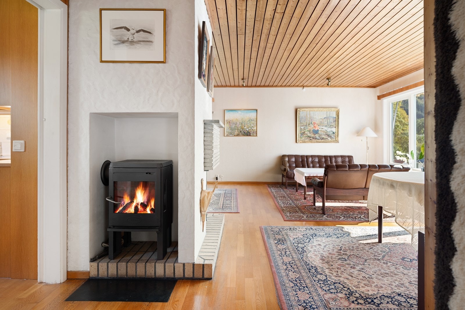 Rentbrennende ildsted (fra 2009) og panelovn (fra 2023) sikrer god og lun varme på kalde dager. Galleribilde