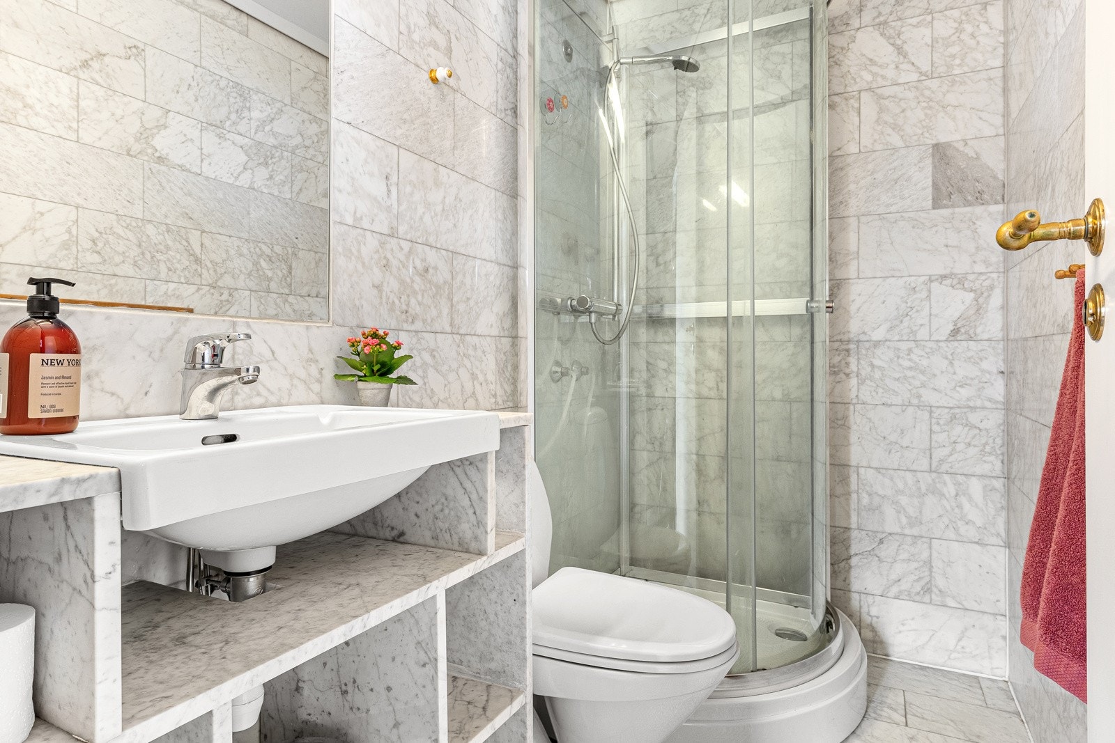 Badet er helfliset med gulvvarme. Det er innredet med servantinnredning med ovenpåliggende servant, dusjkabinett og gulvstående toalett. Galleribilde