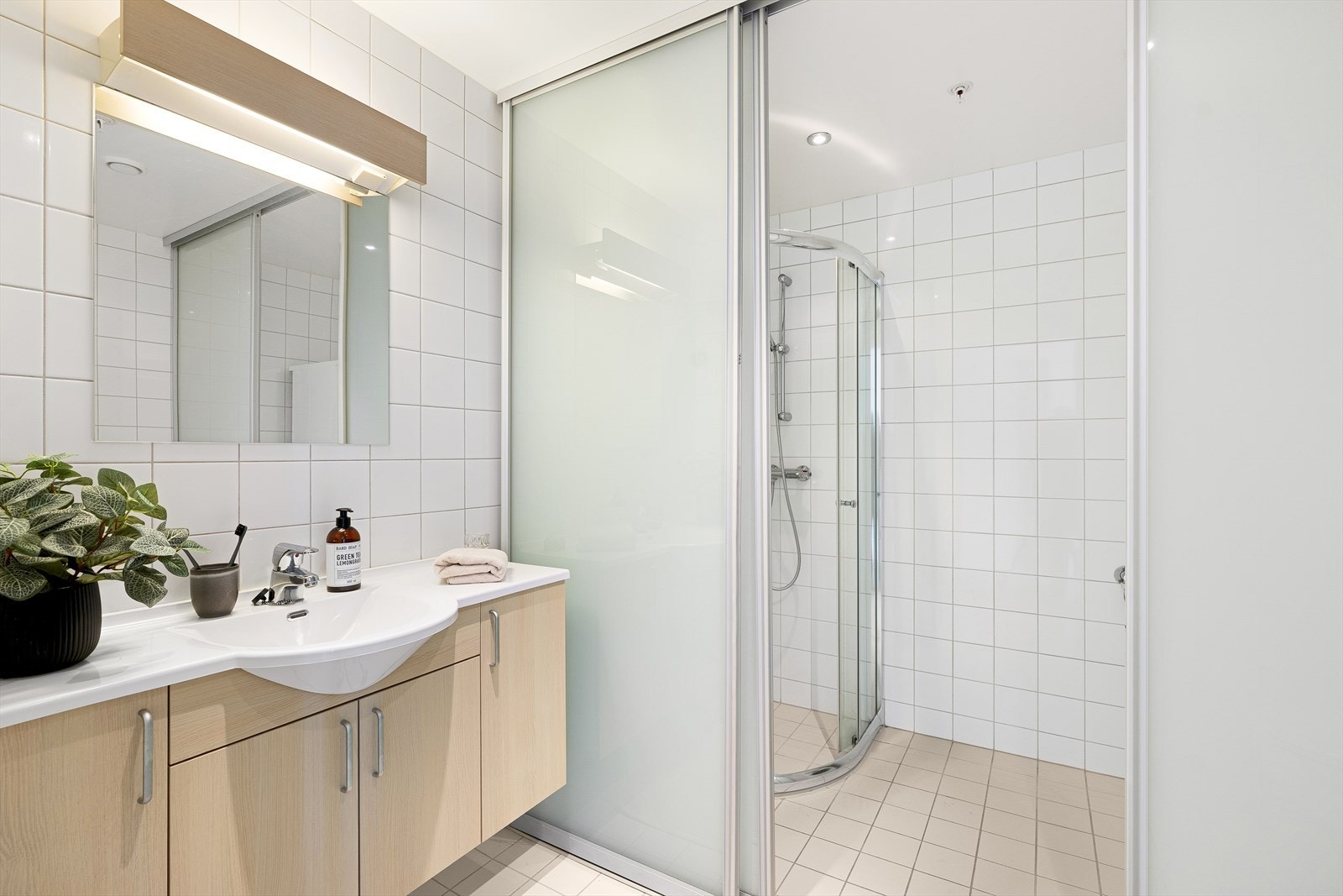 Smart løsning på hovedbadet, skiller av dusj og hvitevarer mot resten av badet Galleribilde