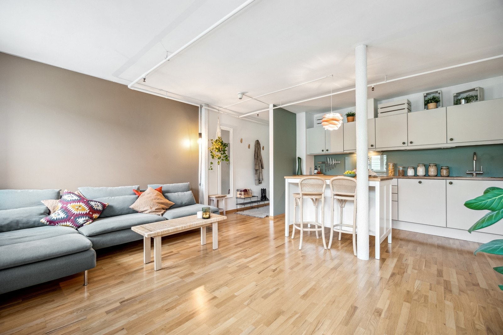 Smart planløsning som kombinerer stue og kjøkken i en hyggelig, lys og åpen flate. Galleribilde