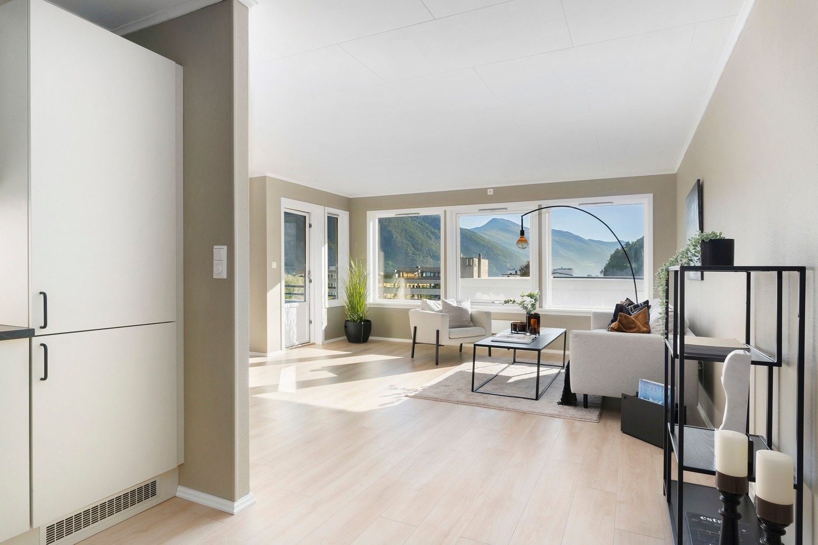 Den halvåpne løsningen mellom stue og kjøkken gjør at samtalen kan flyte godt mens en kokkelerer. Galleribilde