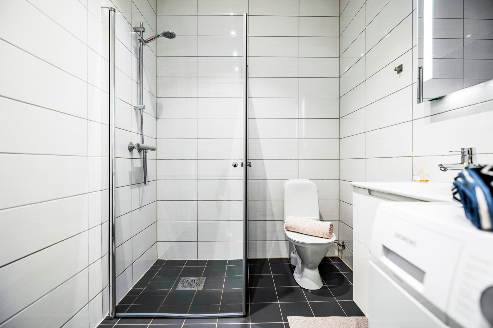 Badet er utstyrt med toalett og et romslig dusjhjørne med innfellbare dører i glass. Galleribilde