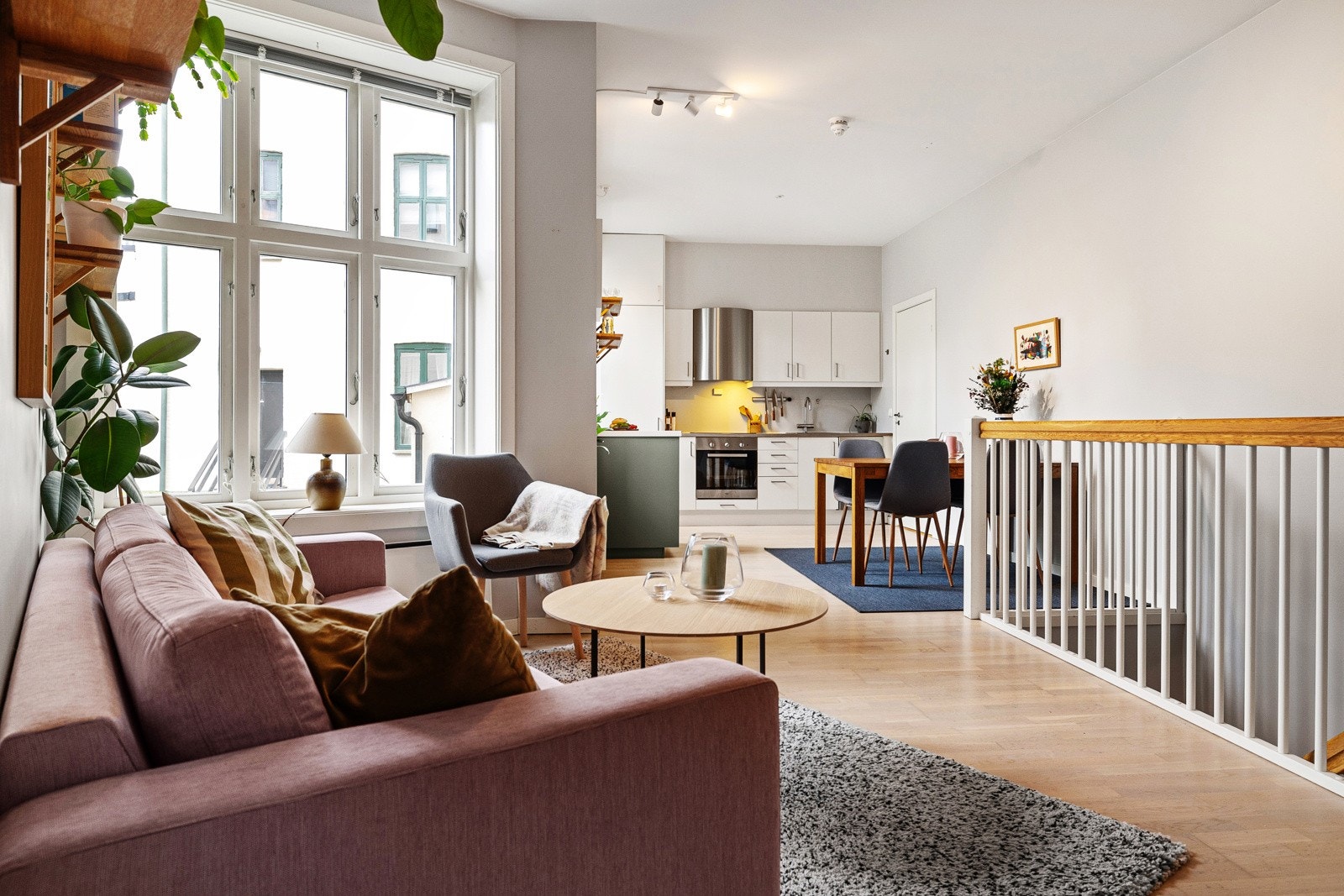 Stilren stue med lekker parkett på gulvet og delikate lysmalte overflater. Galleribilde