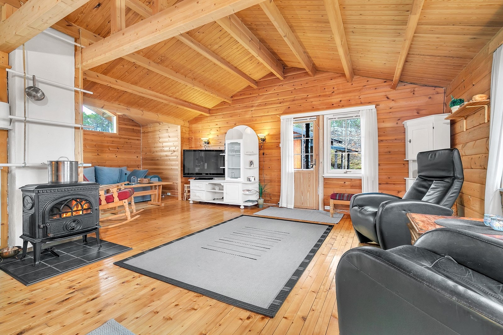 Hytte - Stue med lakkerte furugulv og vegger av tømmer. Galleribilde