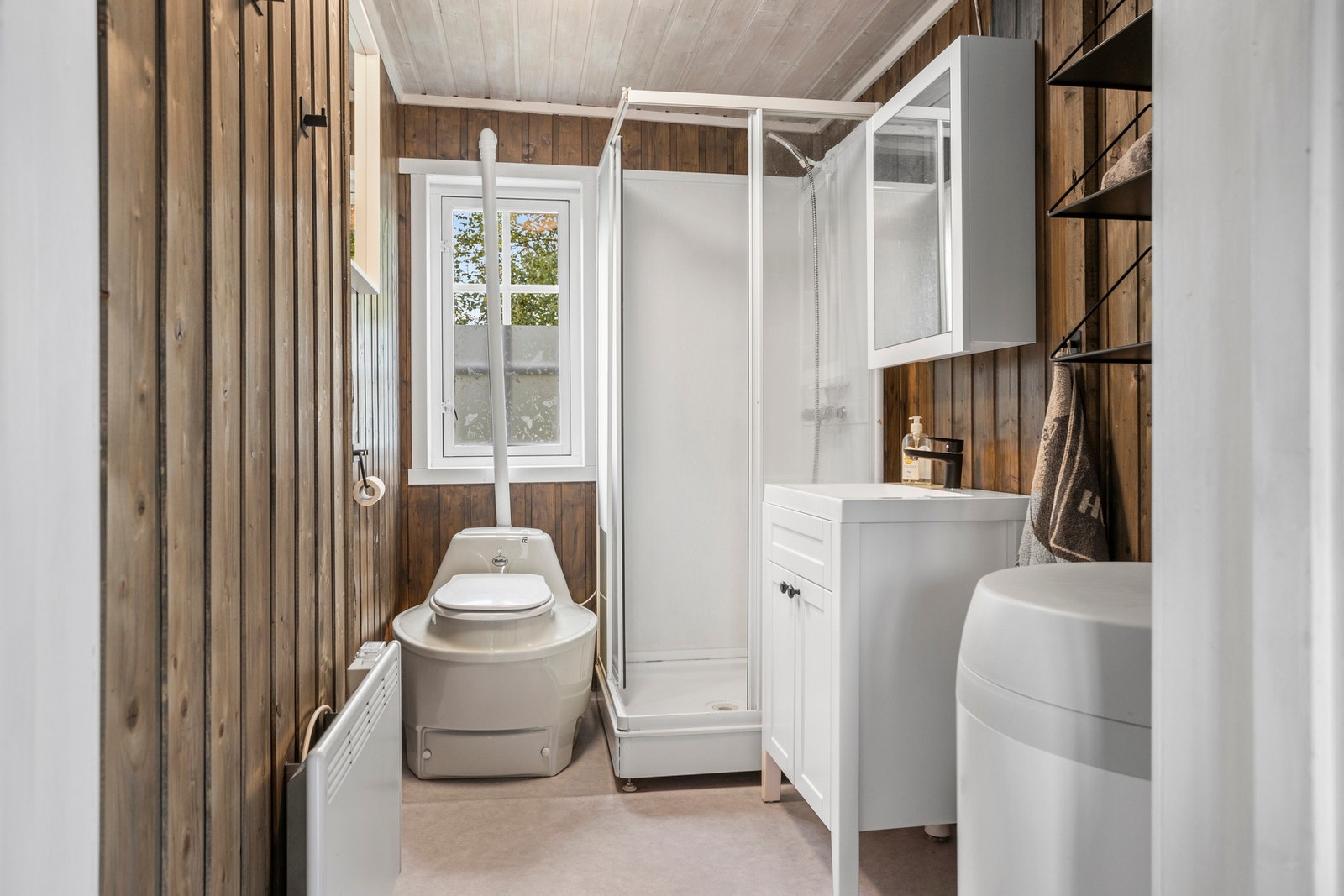 Bad med biotoalett, dusjkabinett og baderomsinnredning Galleribilde