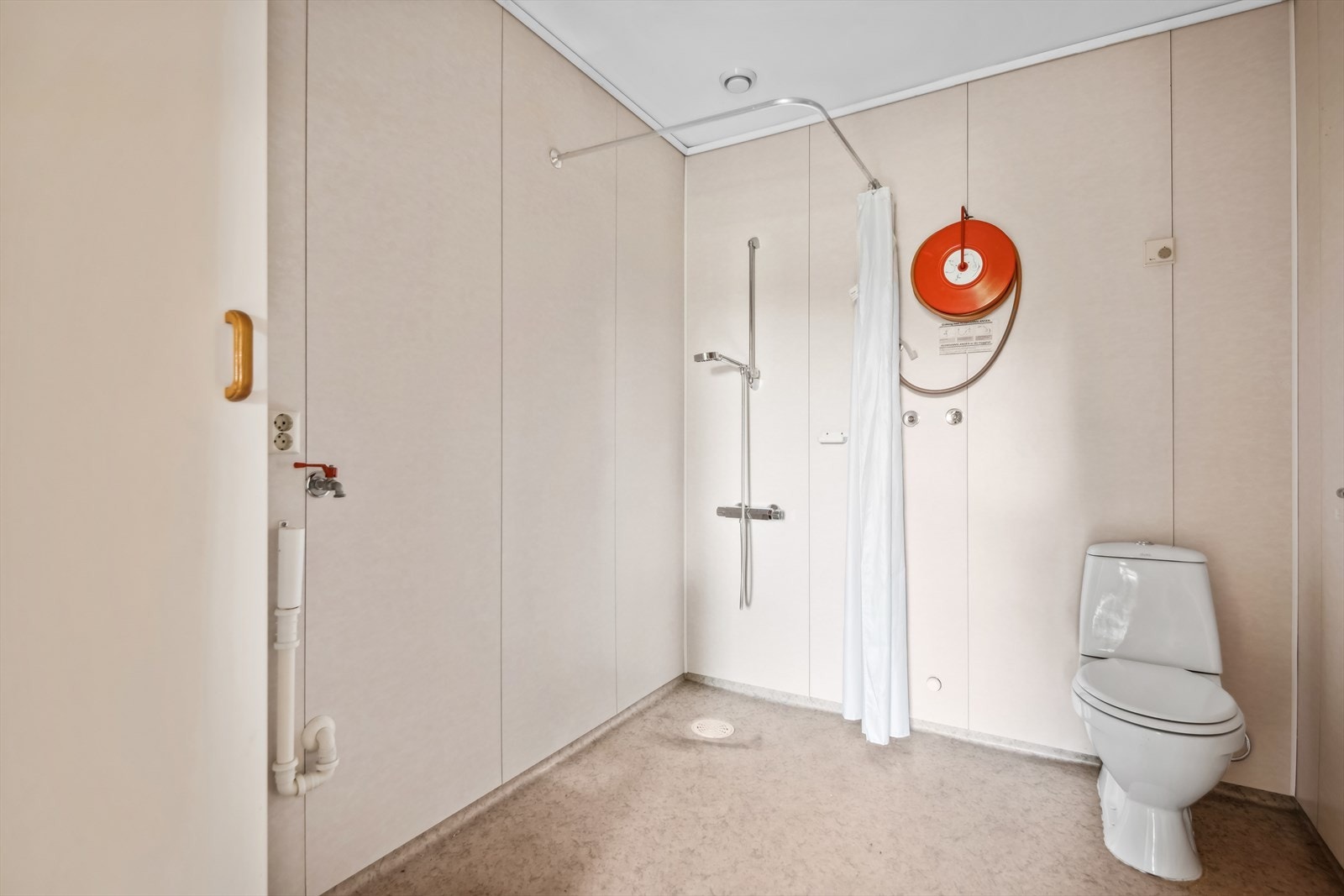 Bad/vaskerom har gulv med varmekabler, baderomsplater på vegg og malte plater i tak. Rommet er innredet med toalett, vask, opplegg for vaskemaskin og dusjhjørne med forheng. Galleribilde