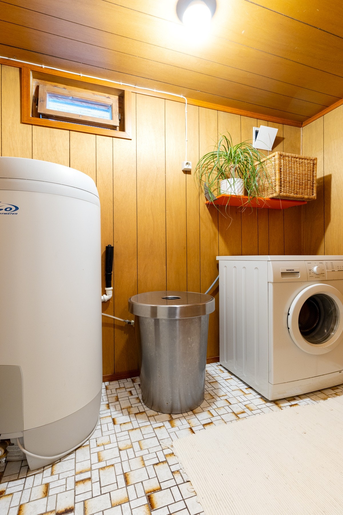 Praktisk vaskerom med plass til vaskemaskin, varmtvannsbereder og hylleløsning. Galleribilde