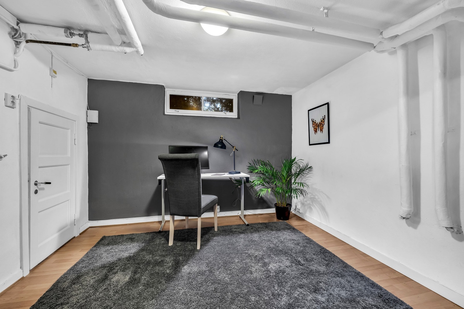 Innredet til kontor i kjeller - rommet er ikke godkjent til varig opphold. Til venstre i bildet er det et rom for oppbevaring Galleribilde