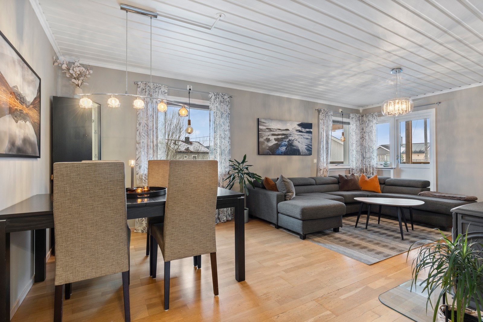 En lys og romslig stue som rommer god plass til sofagruppe og spisebord med tilhørende møblement Galleribilde
