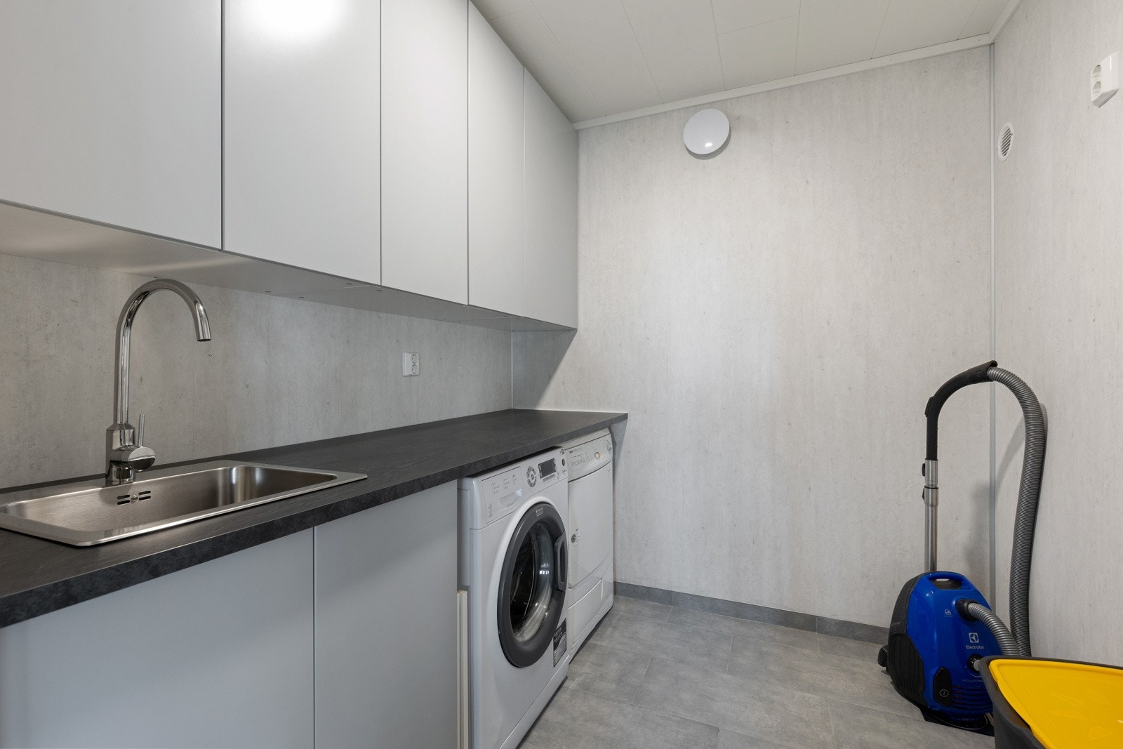 Praktisk innredet vaskerom med gode oppbevaringsmuligheter og opplegg for både vaskemaskin og tørketommel. Galleribilde