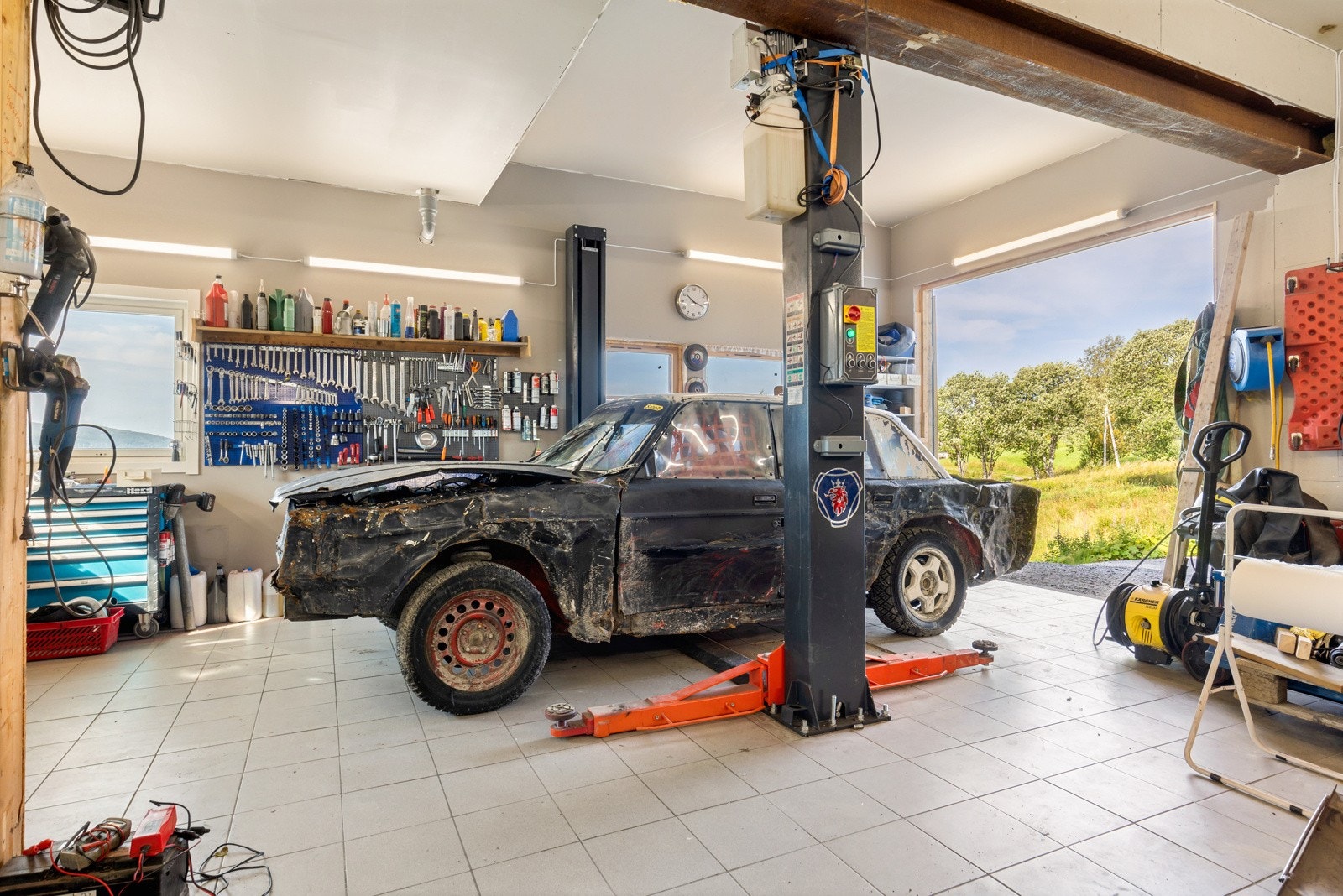 Flislagt garasje med helproff løftesystem, en drøm for den motorinteresserte. Galleribilde