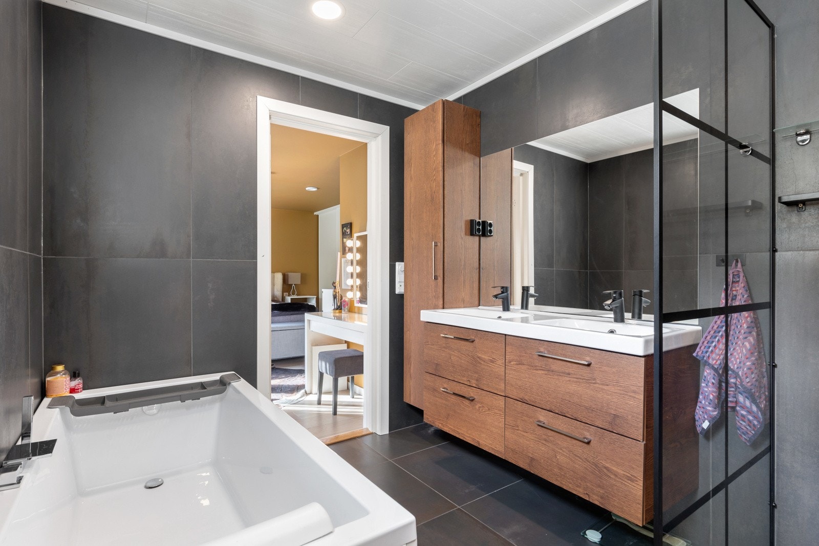 Bad med dobbel servant, badekar, dusjhjørne og luksuriøse materialer ? en oase av velvære. Galleribilde