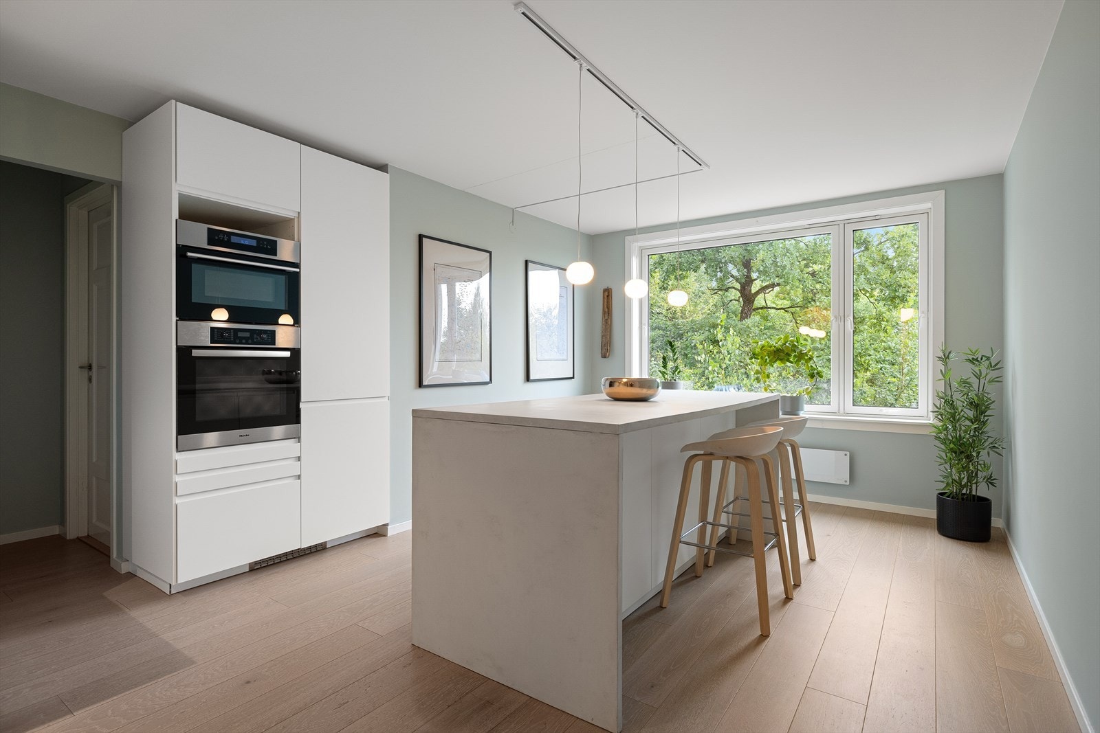 Lekkert kjøkken med vindu som vender ut mot skogen Galleribilde