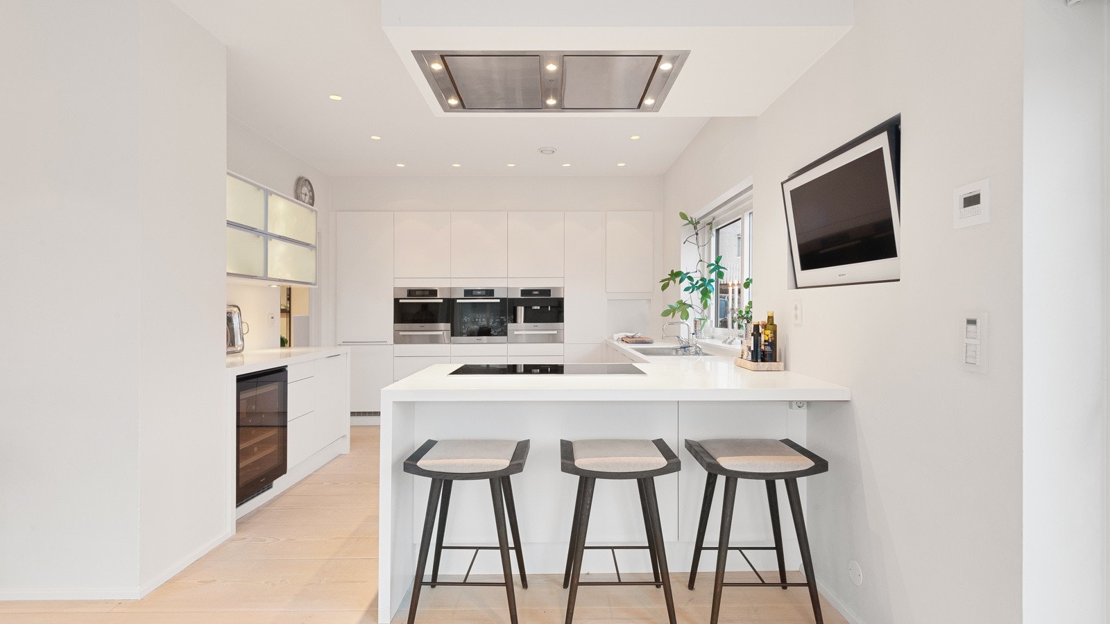 Slitesterk Corian benkeplate, underlimt stålvask med Vola armatur og integrert ventilator fra Røroshetta som styres med fjernkontroll. Galleribilde