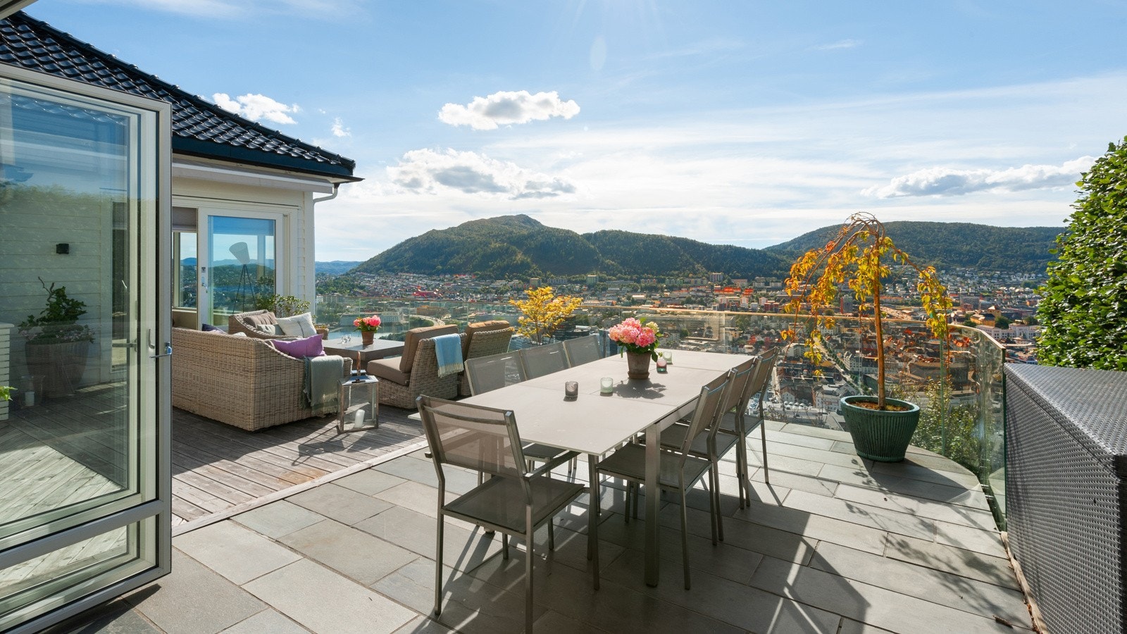 Terrassen ble utvidet i 2010/2011 og det er plass til flere soner. Her ute er det en kombinasjon av lys Oppdalskifer, vedlilkeholdsvennlig Kebony terrassebord og glass. Galleribilde