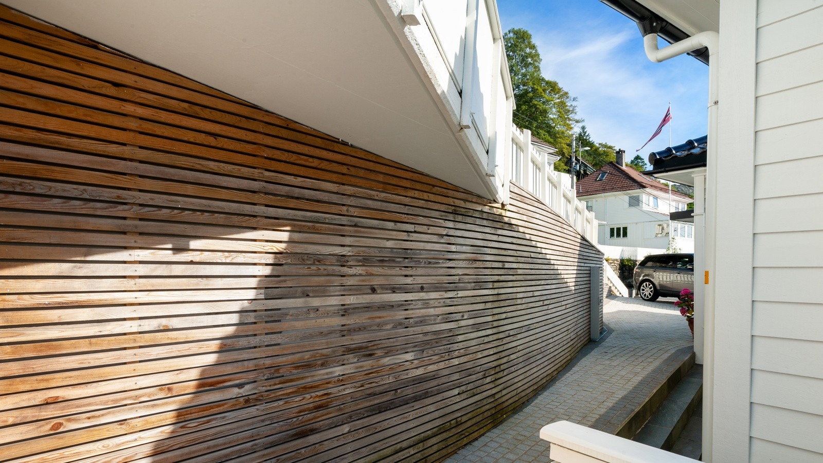 Uteområdene er betydelig påkostet med belegningstein, murer, skifer, bed, spiler, belysning m.m. Det går også varmekabler på hele tunet (p-plassene) og rundt deler av huset. Tomten er også lukket/tilpasset for at hund kan bevege seg fritt på eiendommen. Galleribilde