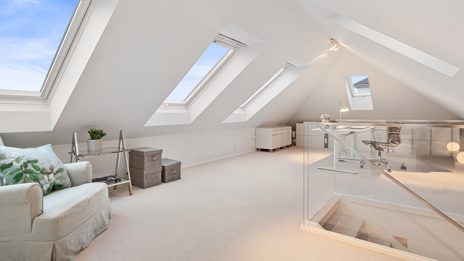 Her oppe er det teppe på gulvet som gir en lun følelse og lyse overflater. Takvinduene slipper inn masse naturlig lys. Galleribilde