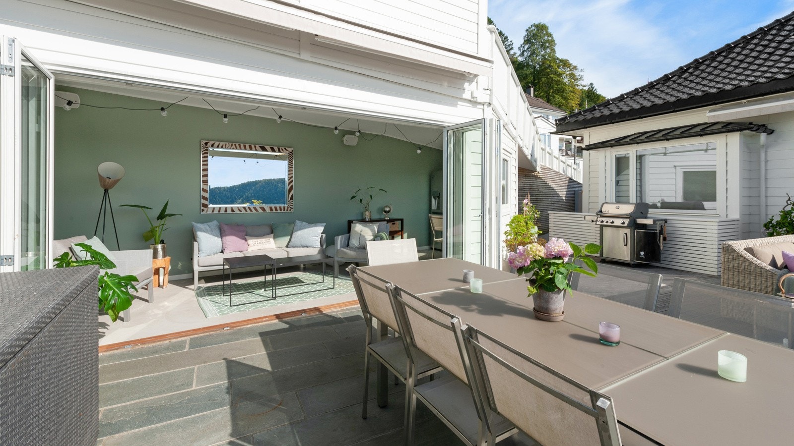 Overbygget utestue med god plass. Her er det innredet med sofa, bord samt et lite kjøkkenhjørne. Helt ideelt hvis regnet plutselig kommer. Galleribilde