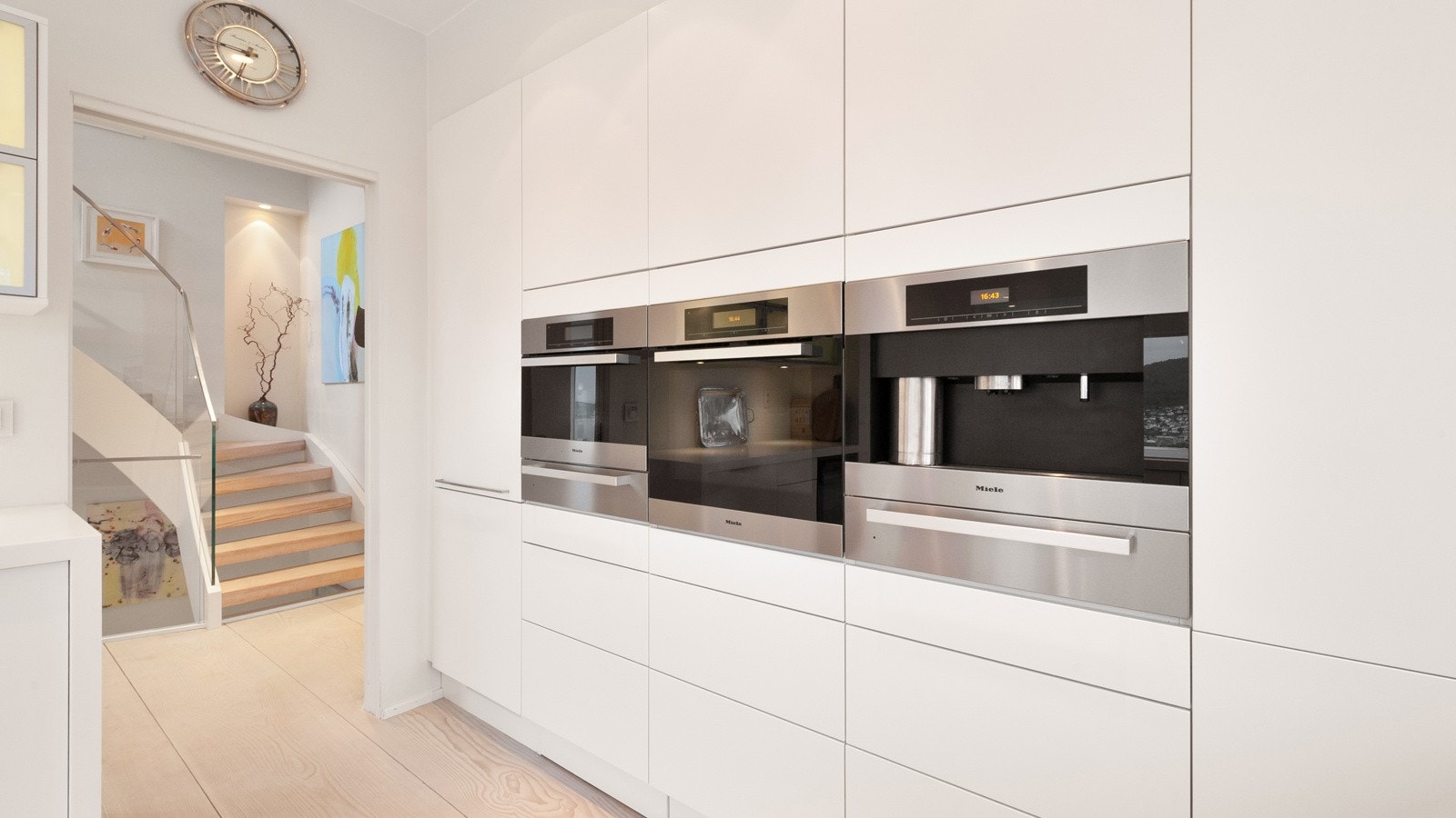 Stekeovn, platetopp med induksjon (93 cm.), kjøleskap/frys, vinskap med to soner, kaffemaskin, dampovn med varmeskuff og fryseskap fra Miele samt to stk. oppvaskemaskiner fra Siemens som prikken over i´en. Galleribilde