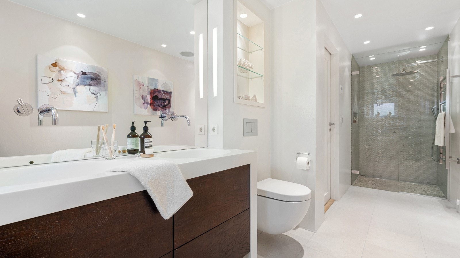 Begge badene har fliser (Kalkfliser) og mosaikk fra Fired Earth, Vola armatur, Villeroy & Boch vegghengt wc, dusjarmatur fra AXOR Hansgrohe, servanter fra Sætrevik Snekkeri, håndkleholder med varme. Her er det også integrert musikkanlegg. Galleribilde