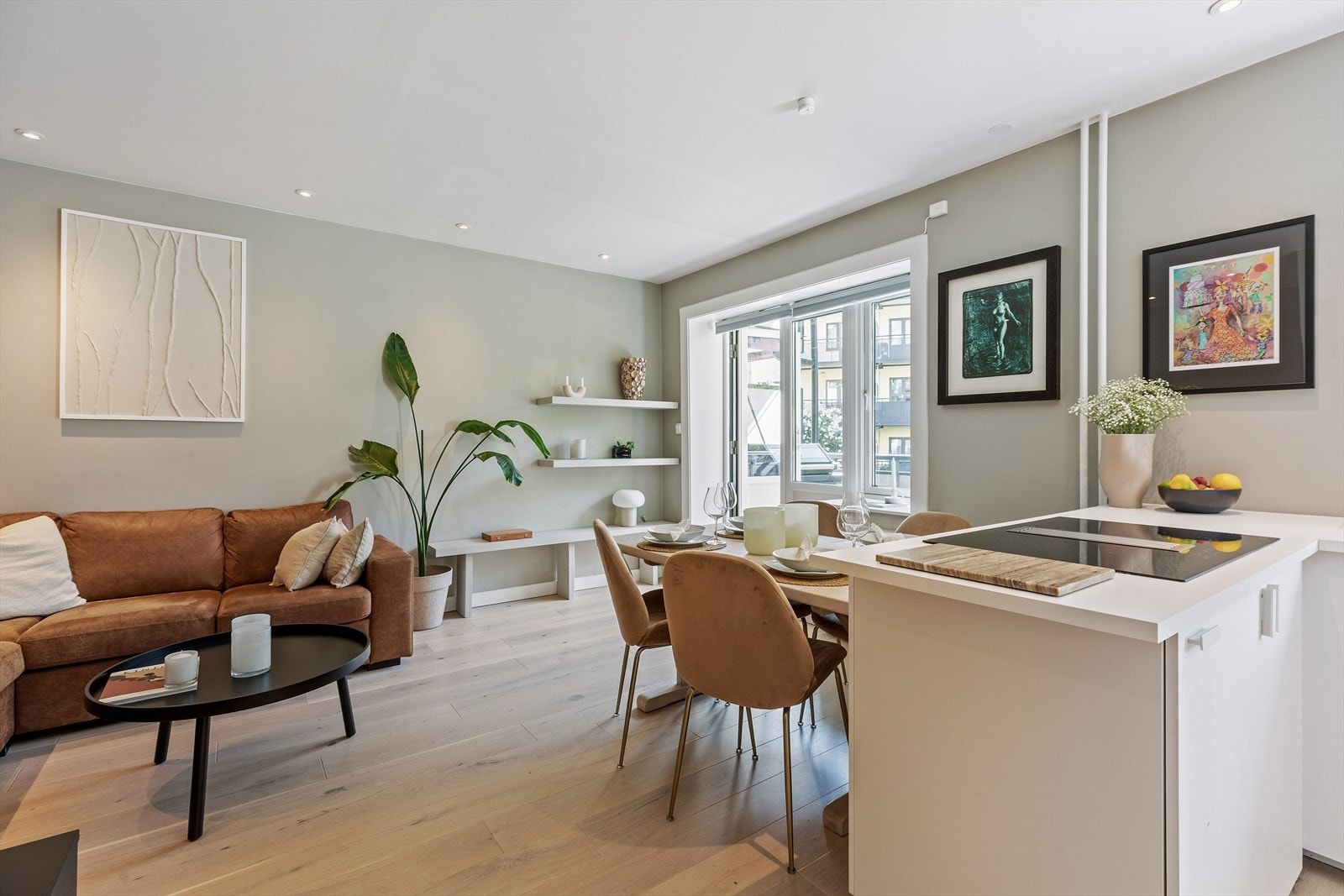 Stuen og kjøkkenet er gjort i en sosial åpen løsning men deles naturlig inn i to soner med bruk av kjøkkenøy Galleribilde