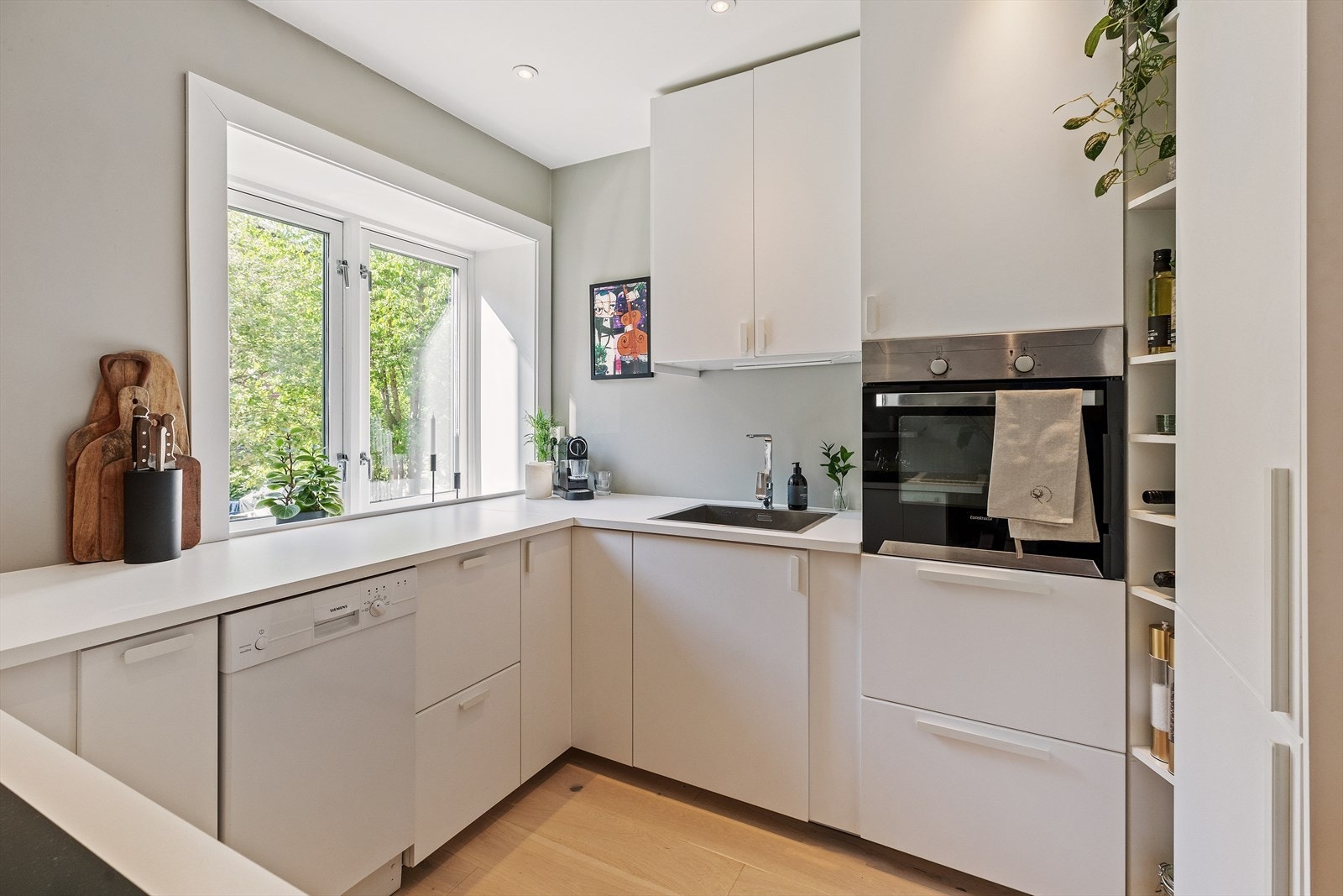 Kjøkken med mye oppbevaringsplass og store arbeidsflater Galleribilde