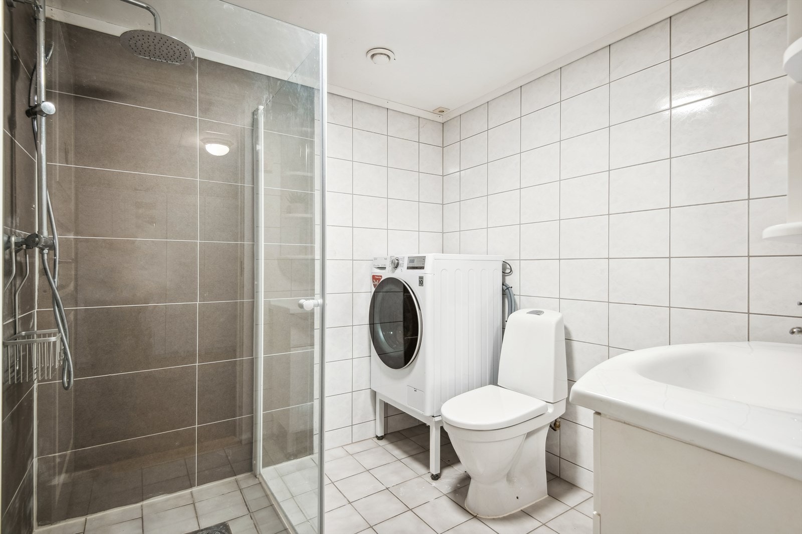 Badet er innreia med skapinreiing, speil, dusjveggar i glas og golvståande toalett. Galleribilde