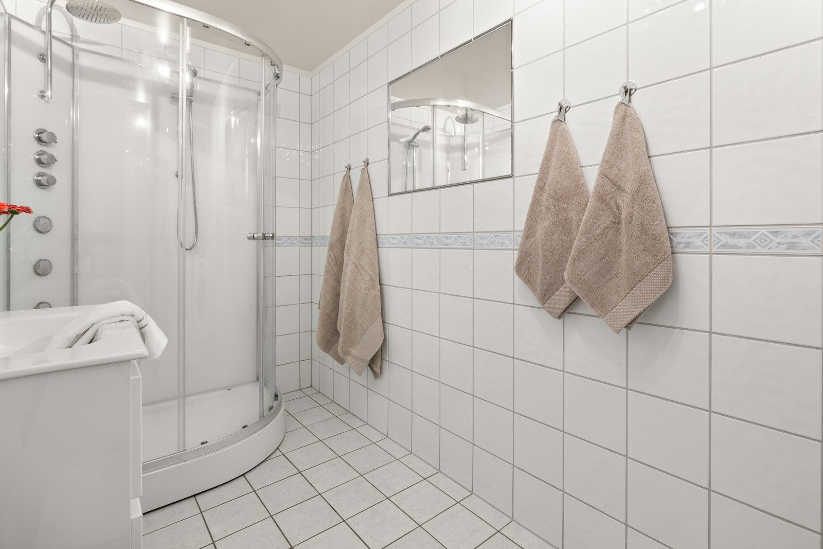 Badet er flislagt med behagelig gulvvarme og inneholder toalett, ny lekker innredning; servant m/skuffer, dusj m// regnfallsdusj og steam, speil m/belysning og opplegg for vaskemaskin Galleribilde