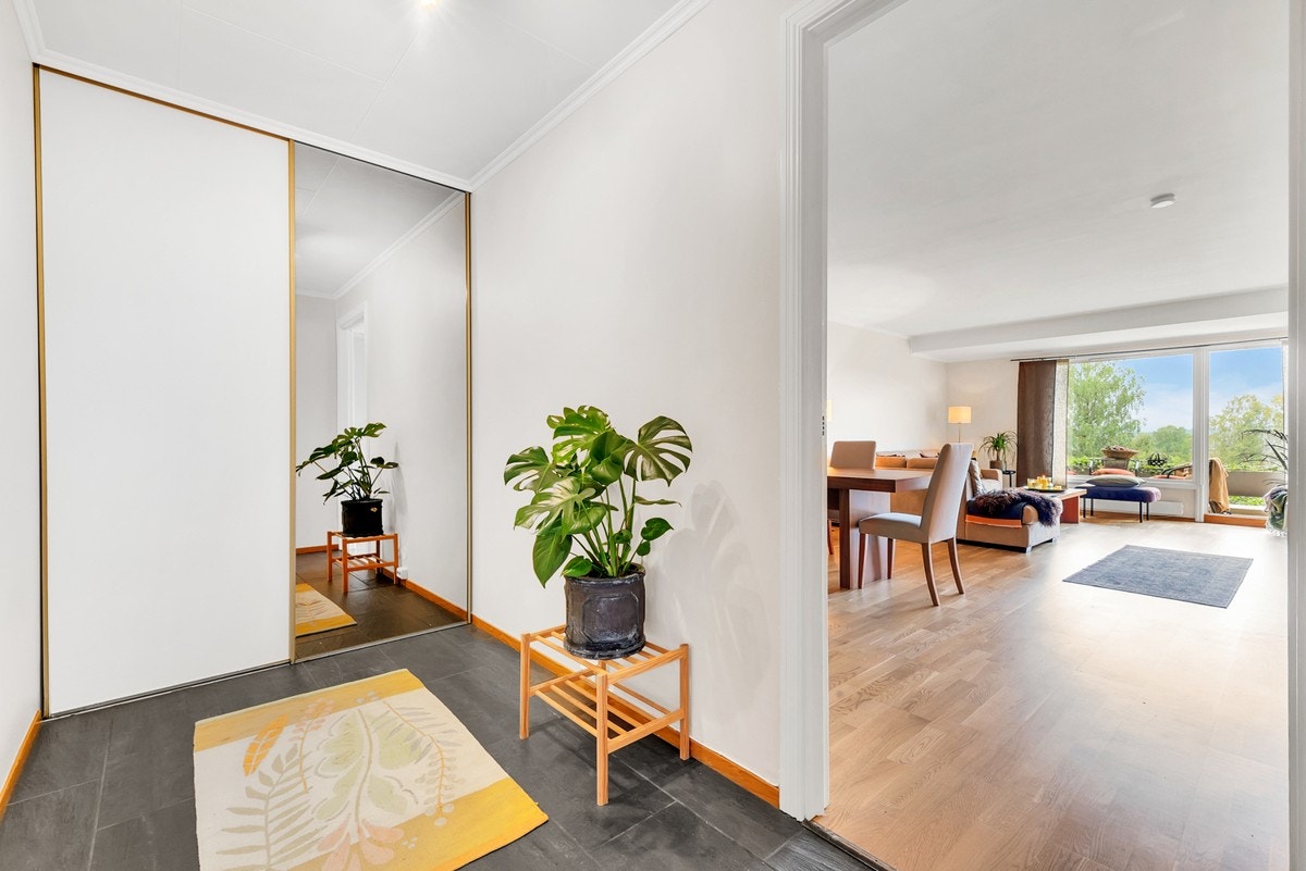 Flislagt entré med skyvedørsgarderobe. Galleribilde