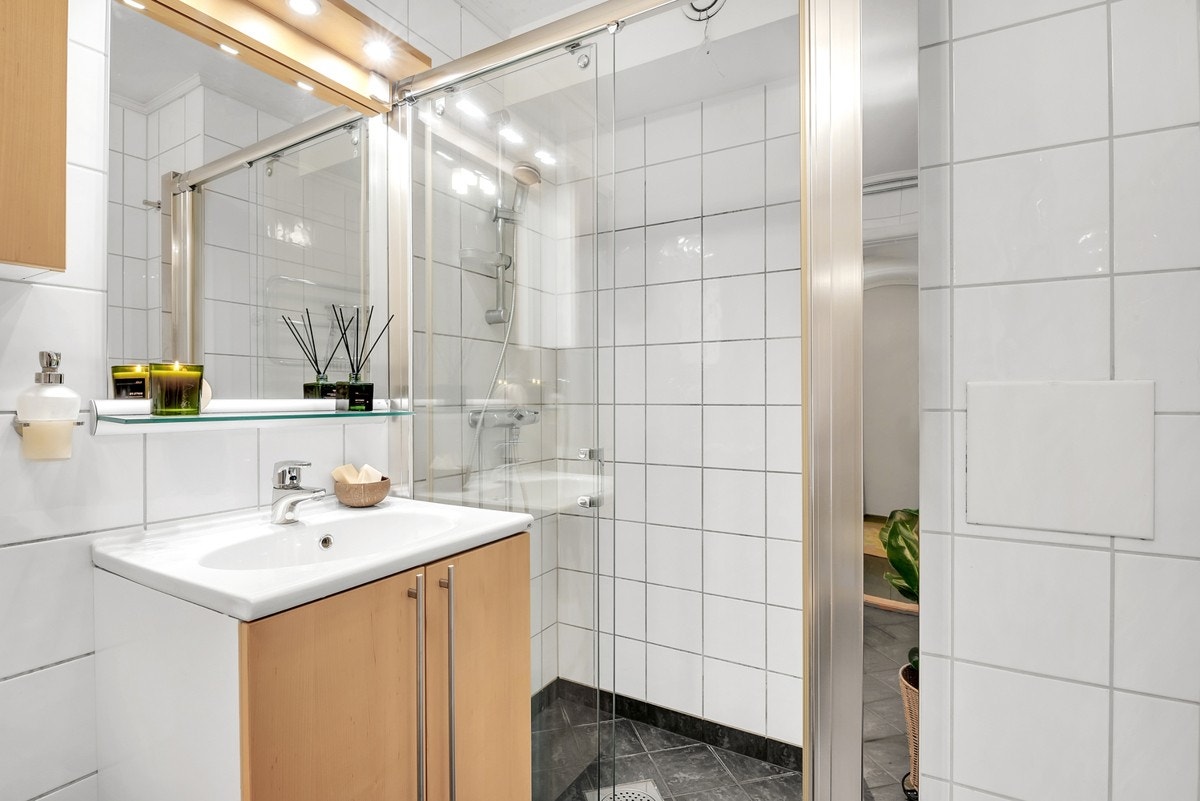 Praktisk baderomsinnredning samt dusj med fast felt og skyvedør i herdet glass. Galleribilde