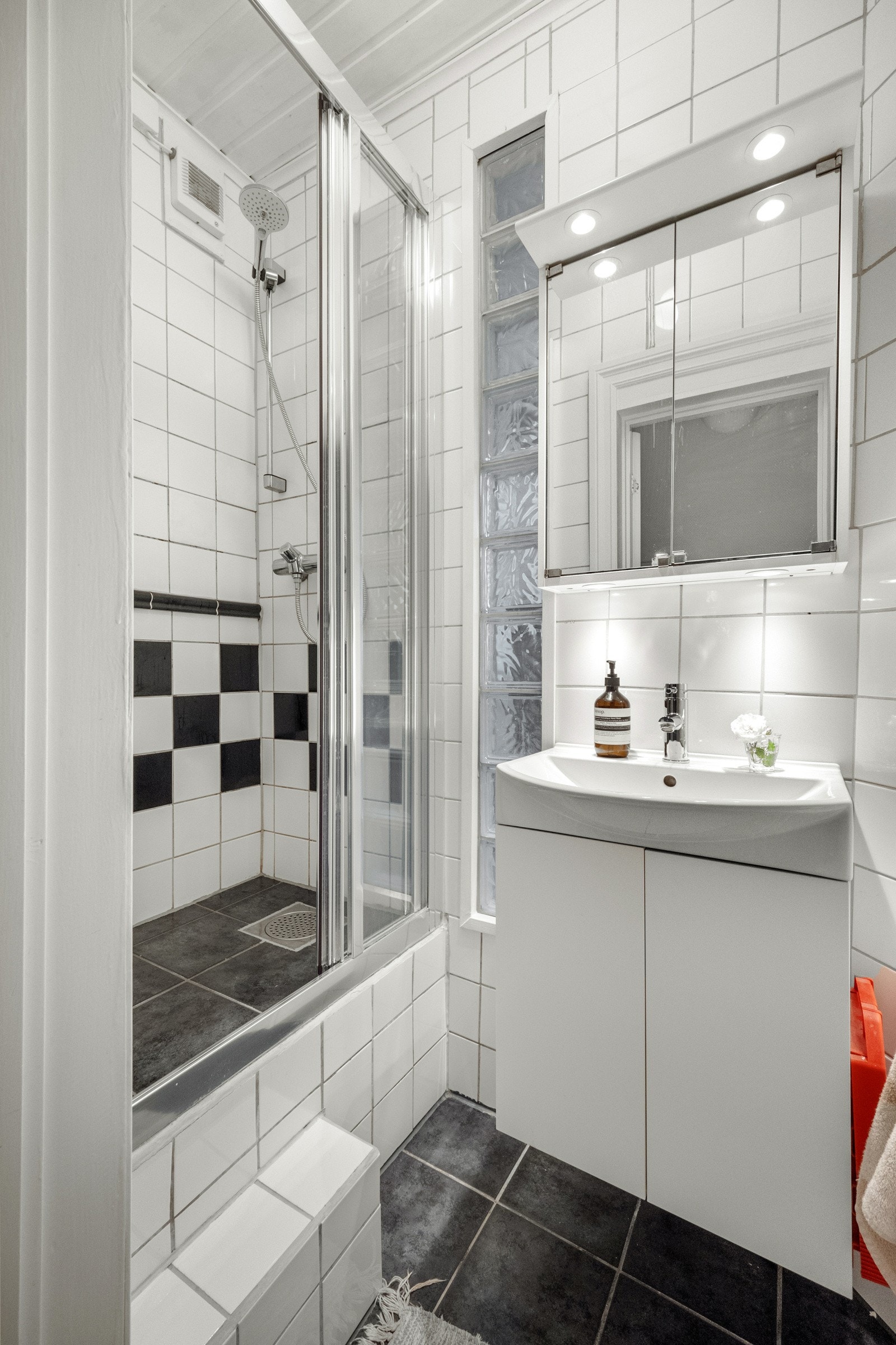Badet er innredet med opphøyet dusjhjørne, servant med skapinnredning og speilskap med belysning. Galleribilde